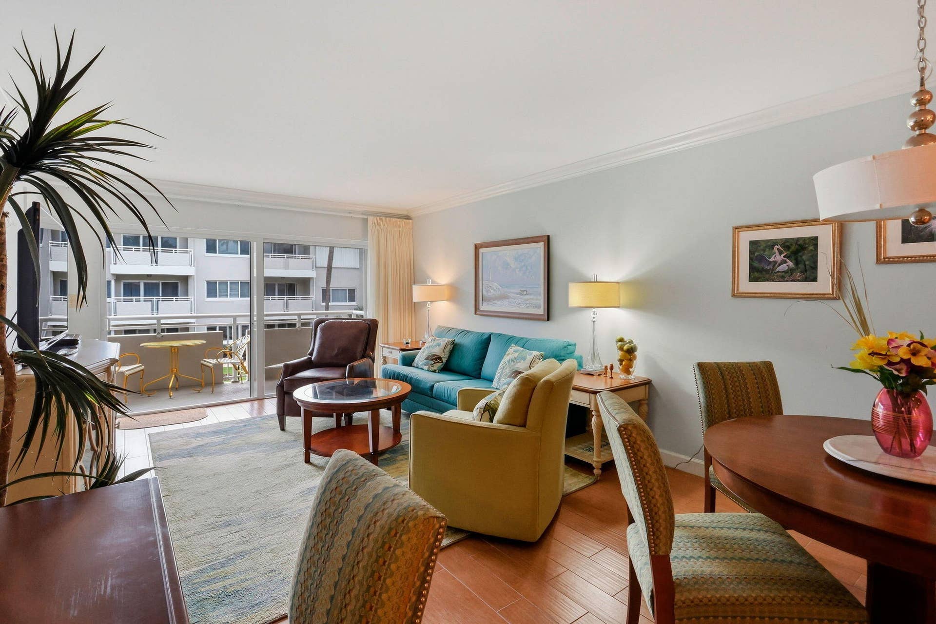1198 Hillsboro Mile, #210, Hillsboro Beach, FL 33062 Wood-finish flooring throughout, bright balcony access with sliding glass doors, and a ceiling-mounted light fixture