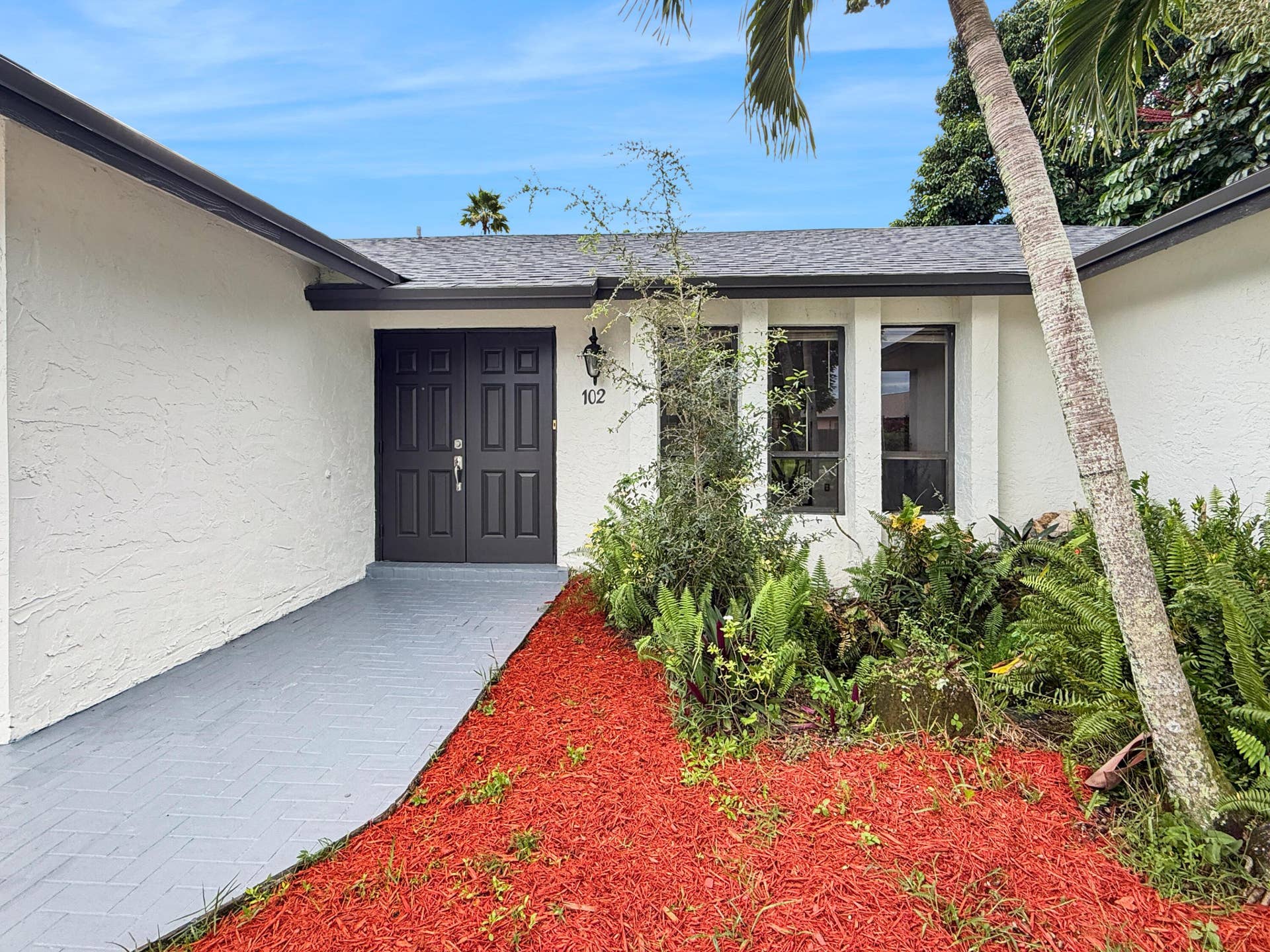 White stucco exterior with a gray shingle roof