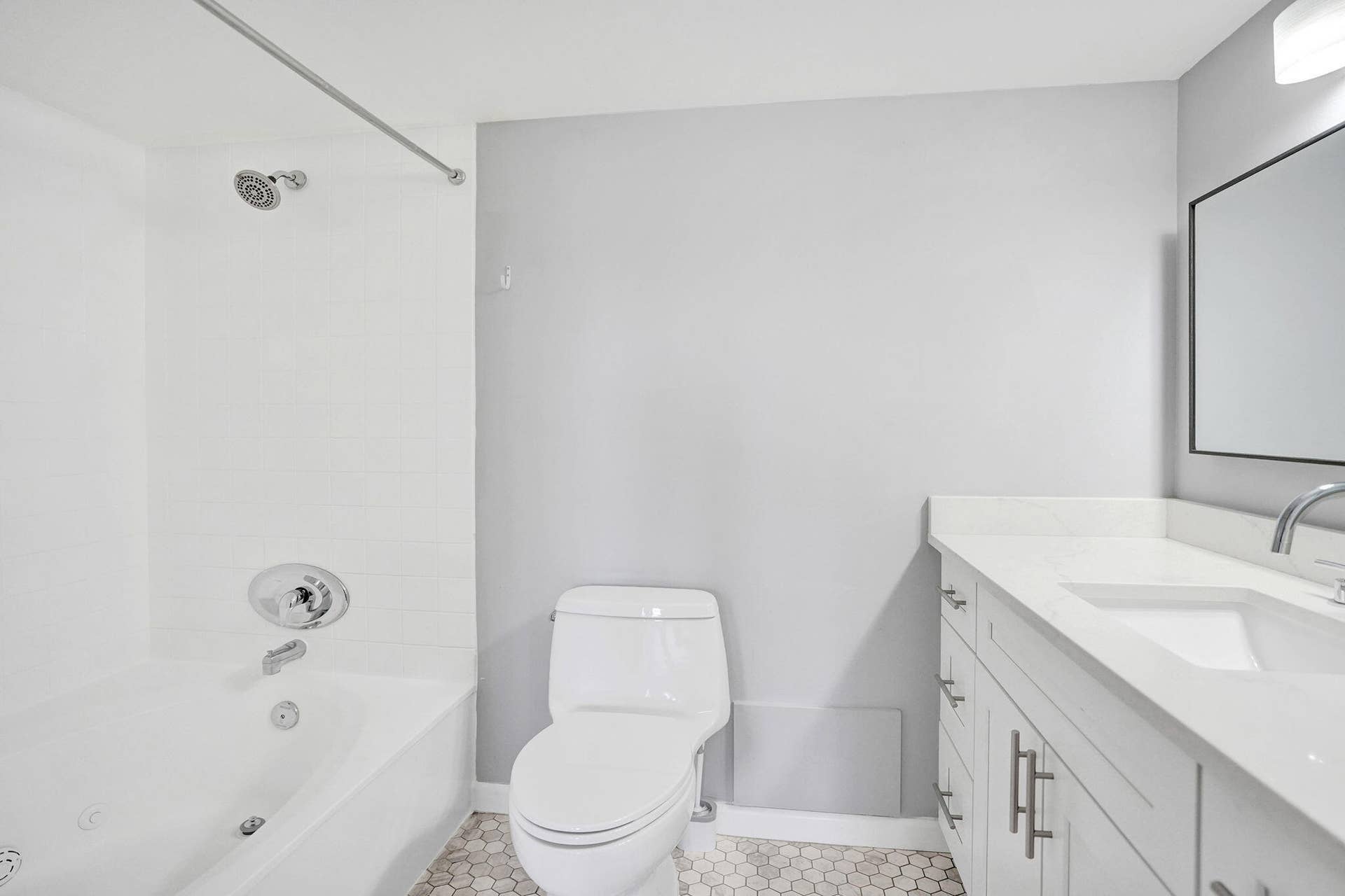 Contemporary bathroom featuring a white vanity and a garden bathtub with jets