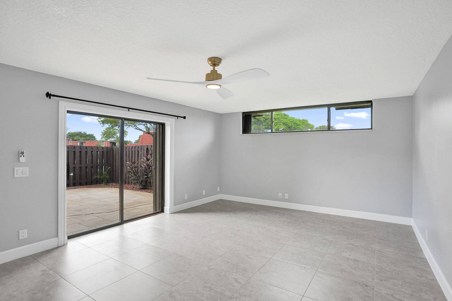 Tile flooring with a matte finish, sliding glass door to an outdoor patio, horizontal window, for added natural light