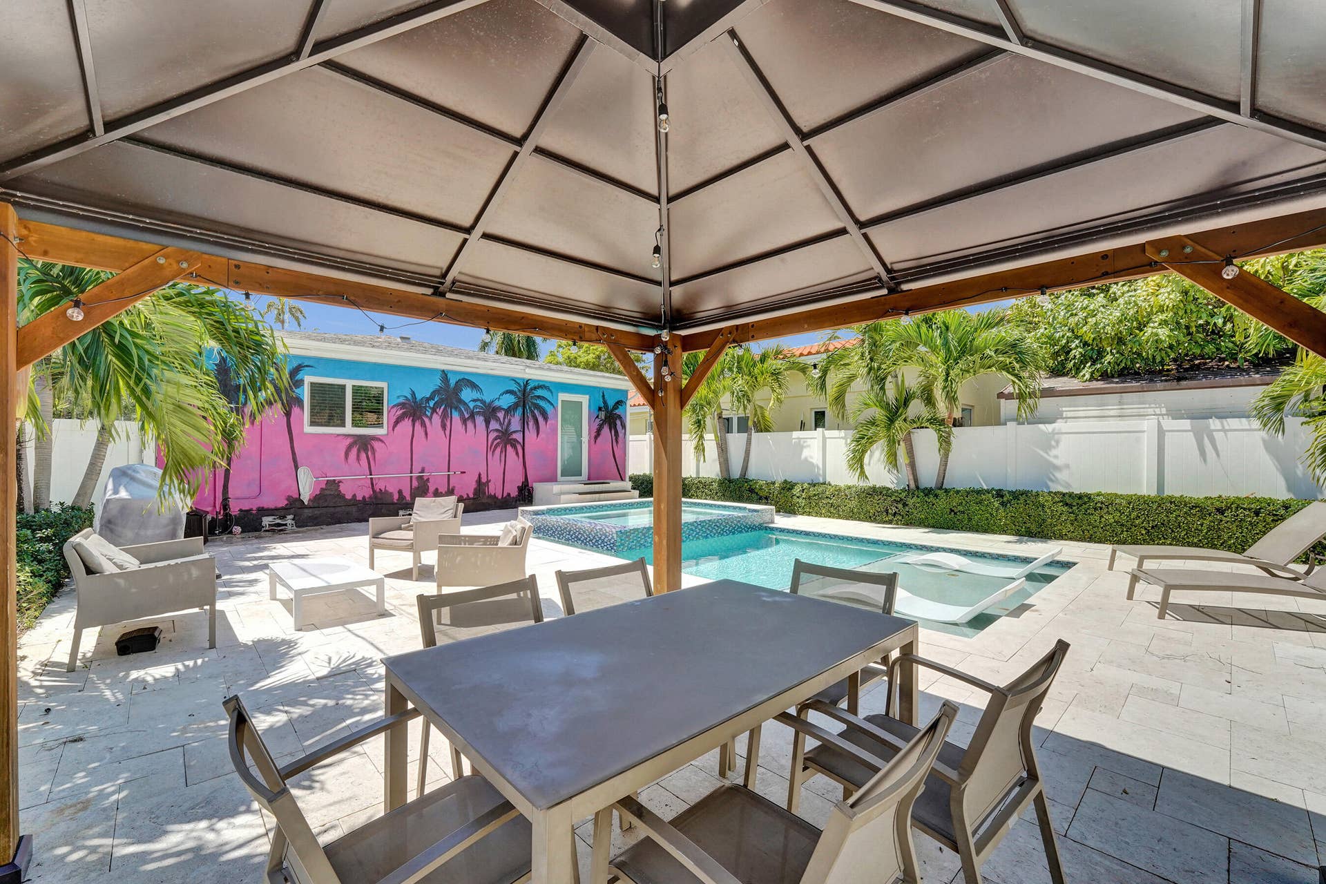 Covered patio with a built-in pool, integrated spa, and surrounding hardscaping
