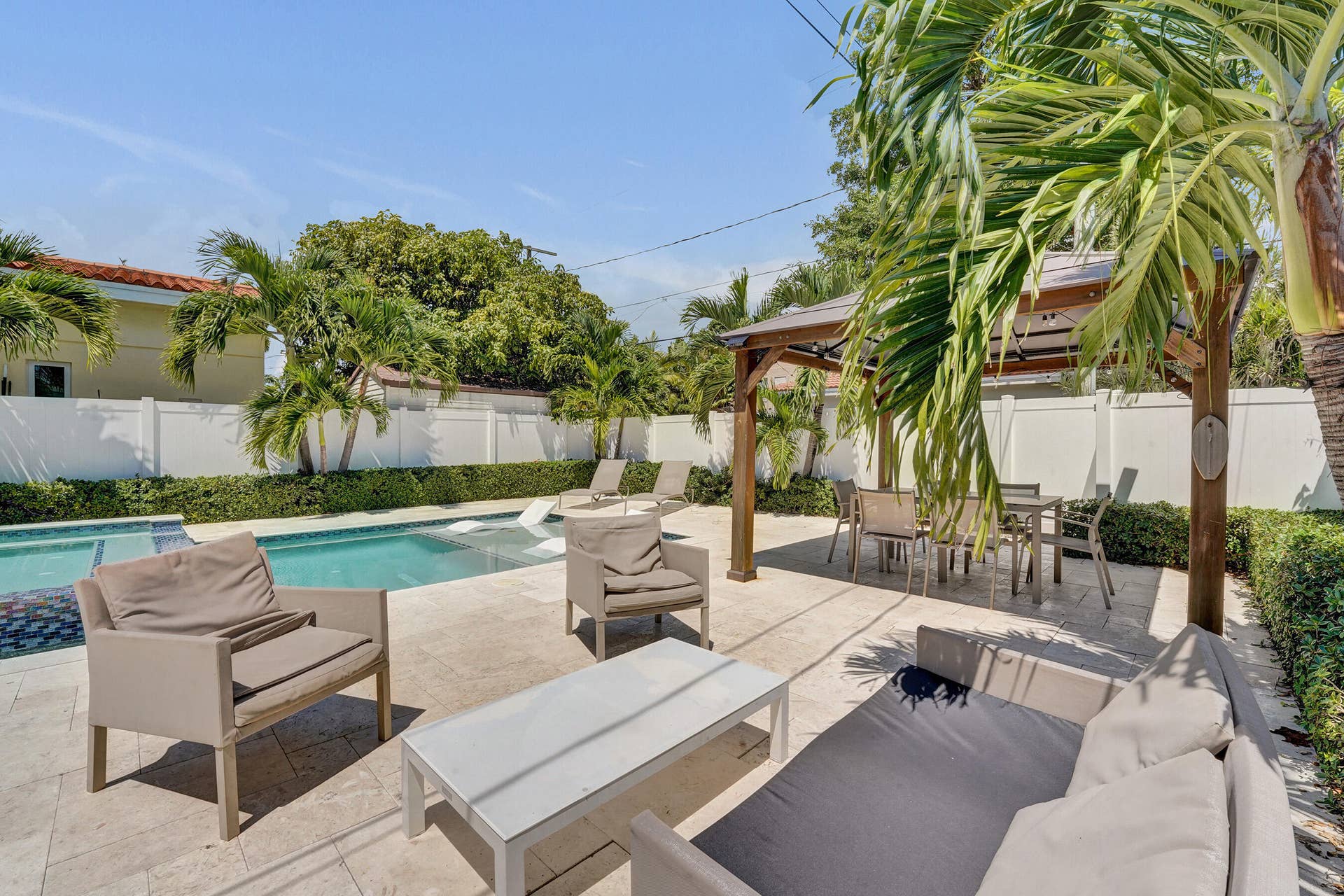 Outdoor living space featuring a swimming pool, spacious paved patio, and a dedicated covered dining area