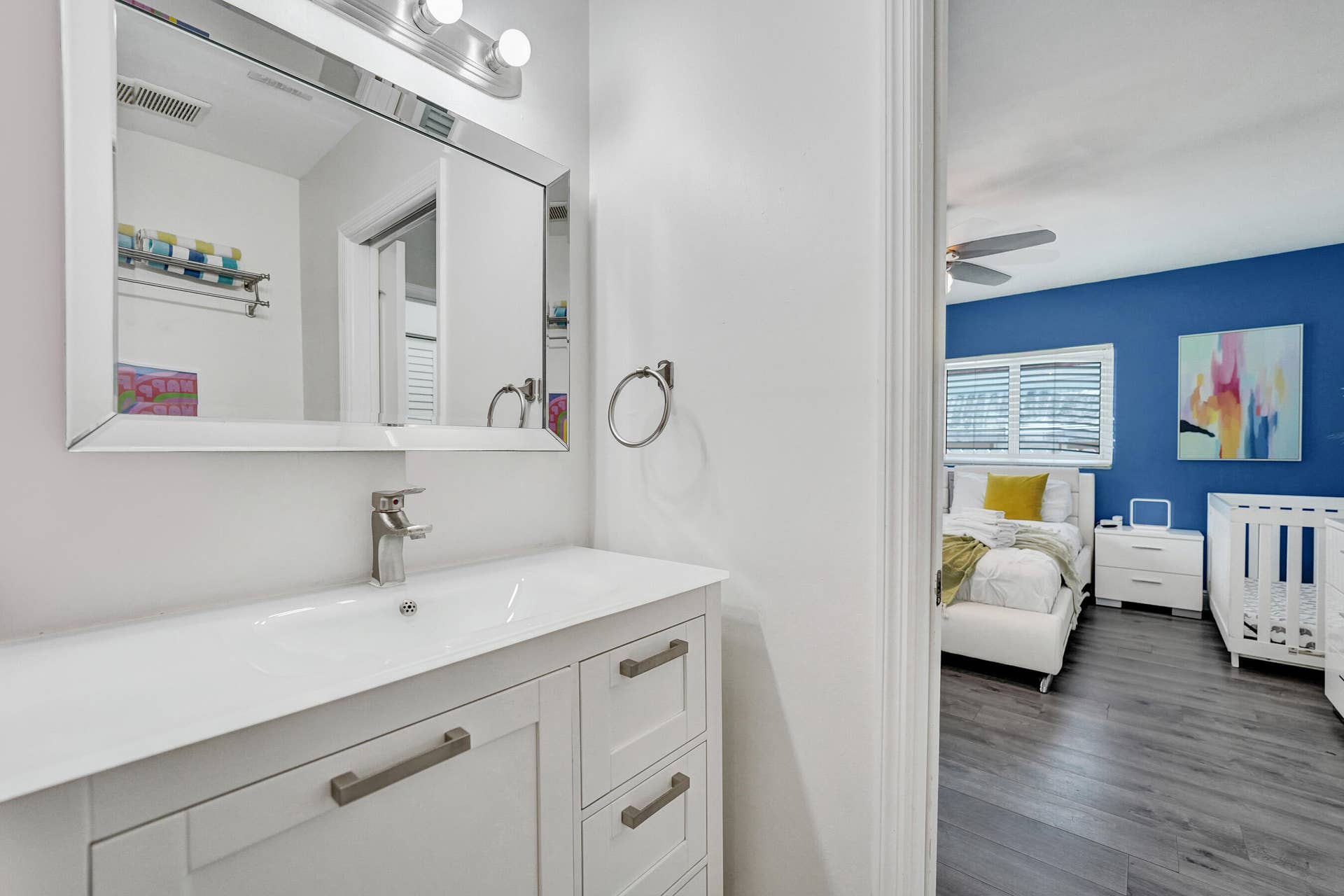 Contemporary vanity with integrated sink, brushed nickel faucet, and overhead bar lighting