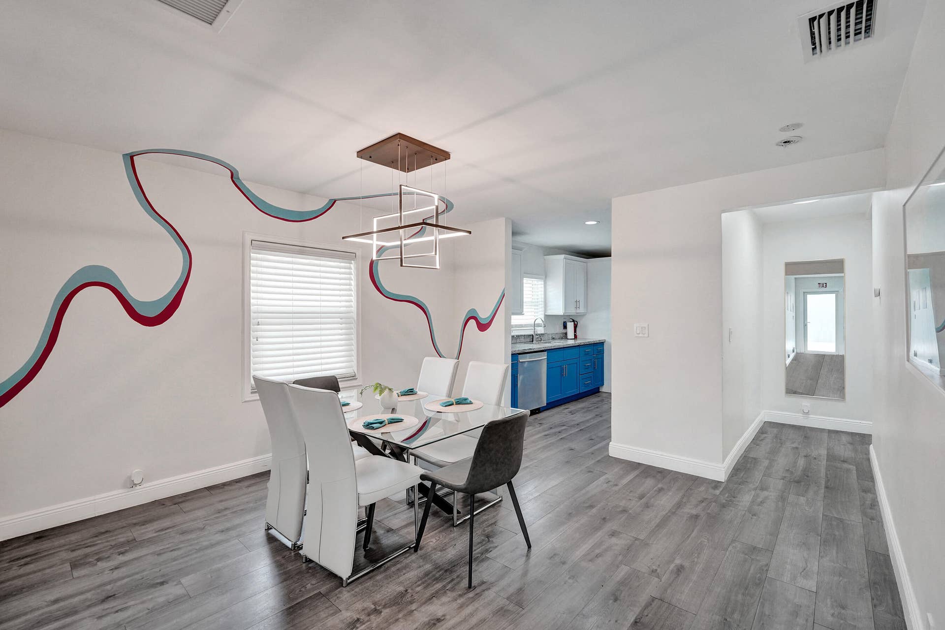 Dining area with wood-finish flooring, a modern geometric chandelier, and window blinds