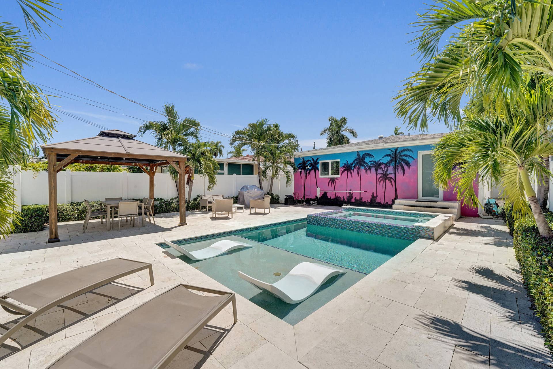 Outdoor living space featuring a swimming pool, integrated spa, and a gazebo with a solid roof