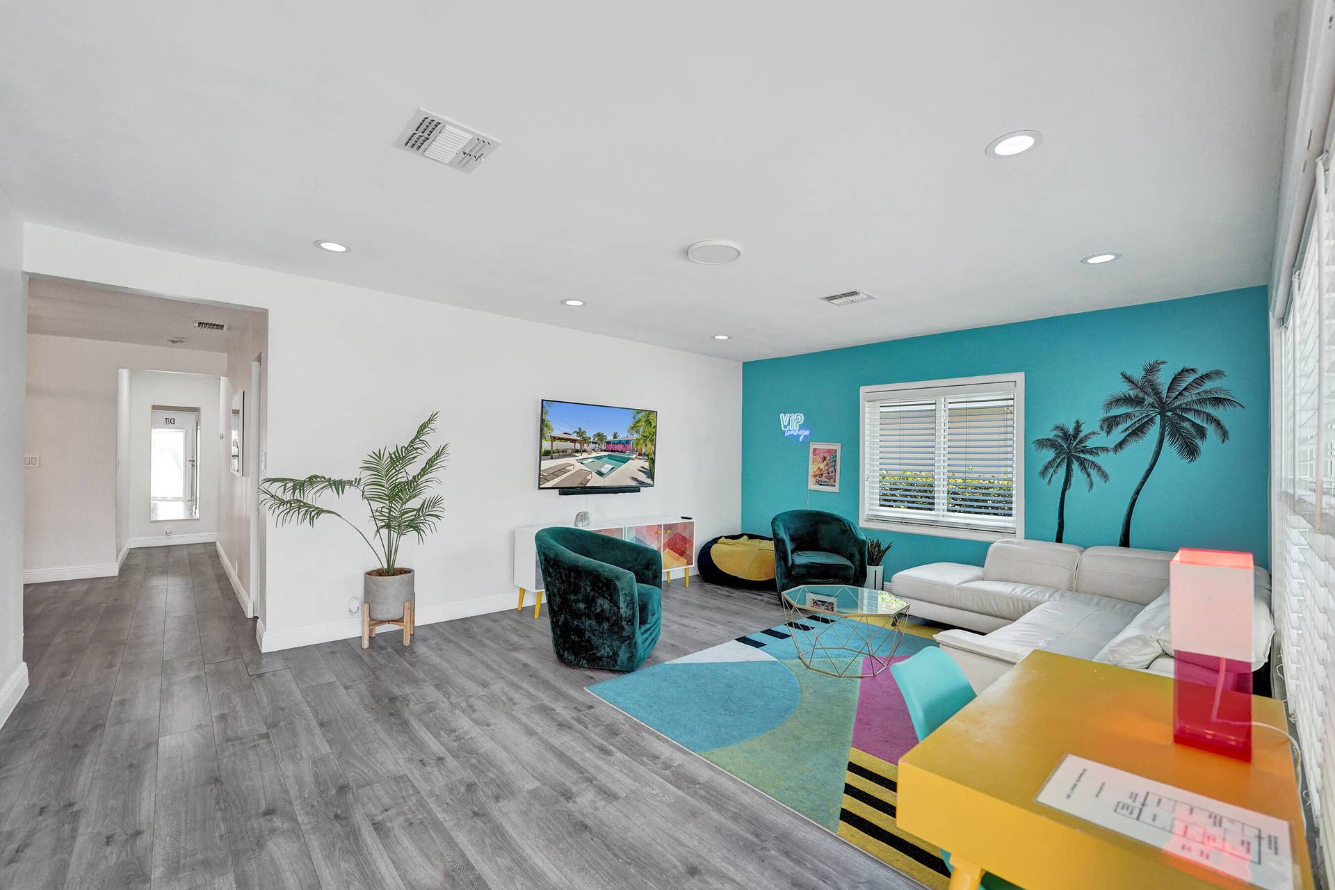 Spacious living area featuring wood-finish flooring, recessed lighting, and a painted accent wall