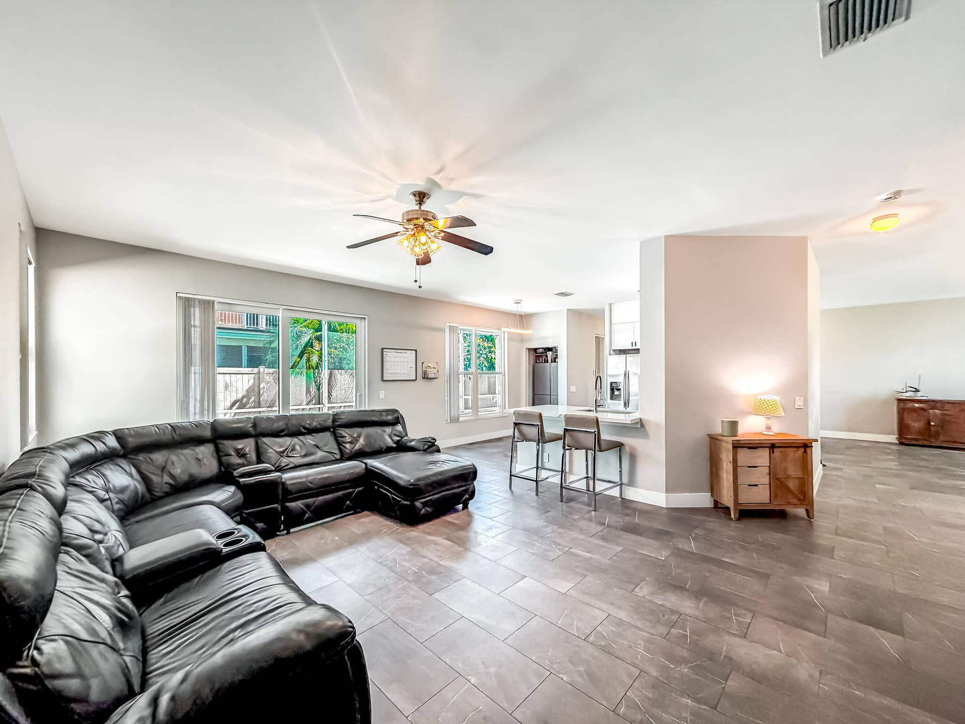 18980 CONCERTO Drive, Boca Raton, FL 33498 Expansive great room featuring large format tile flooring, a ceiling fan with integrated lighting, and multiple windows