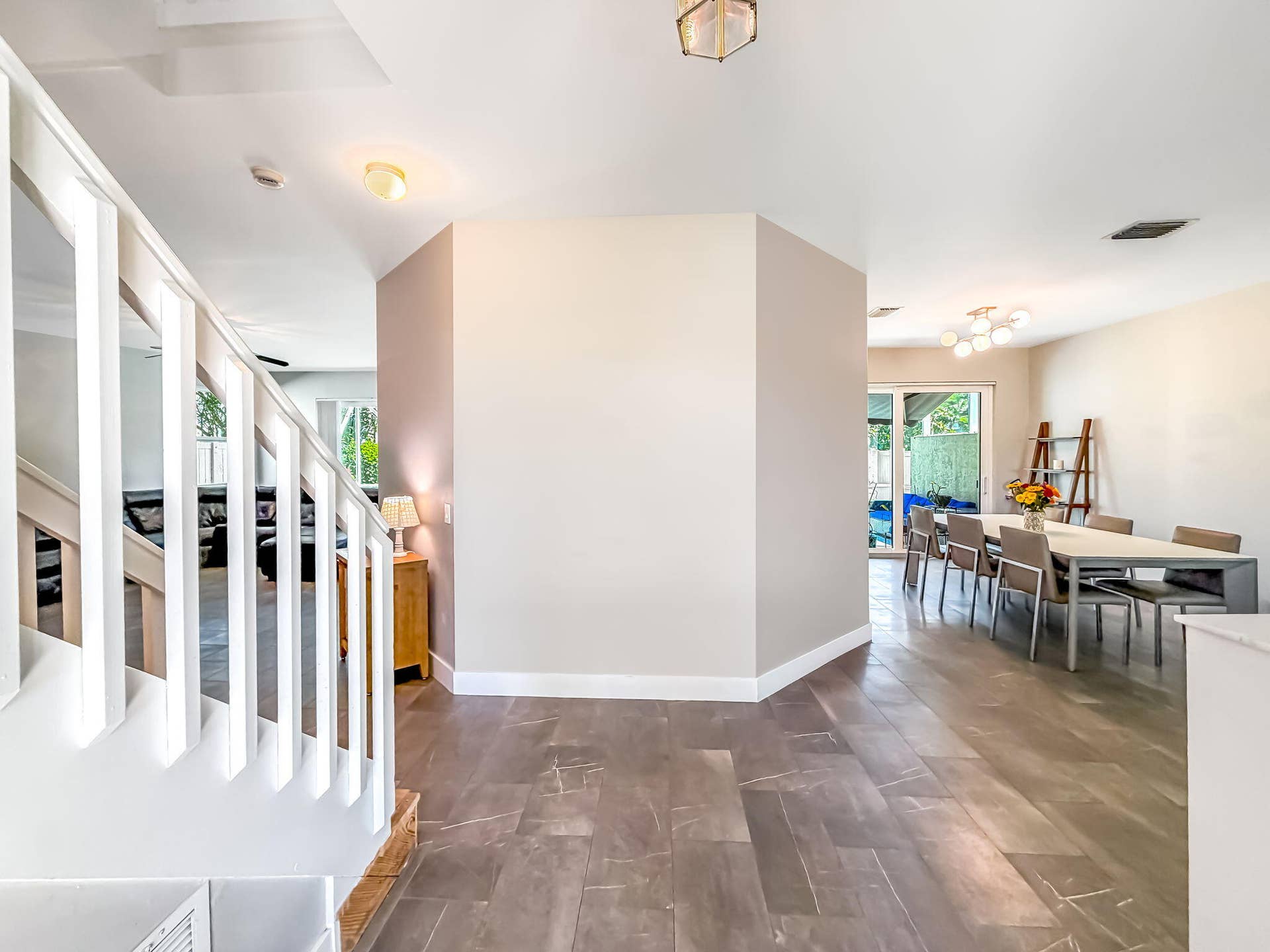 18980 CONCERTO Drive, Boca Raton, FL 33498 Open floor plan featuring wood-finish flooring, a contemporary staircase, and a dining area with a sliding glass door