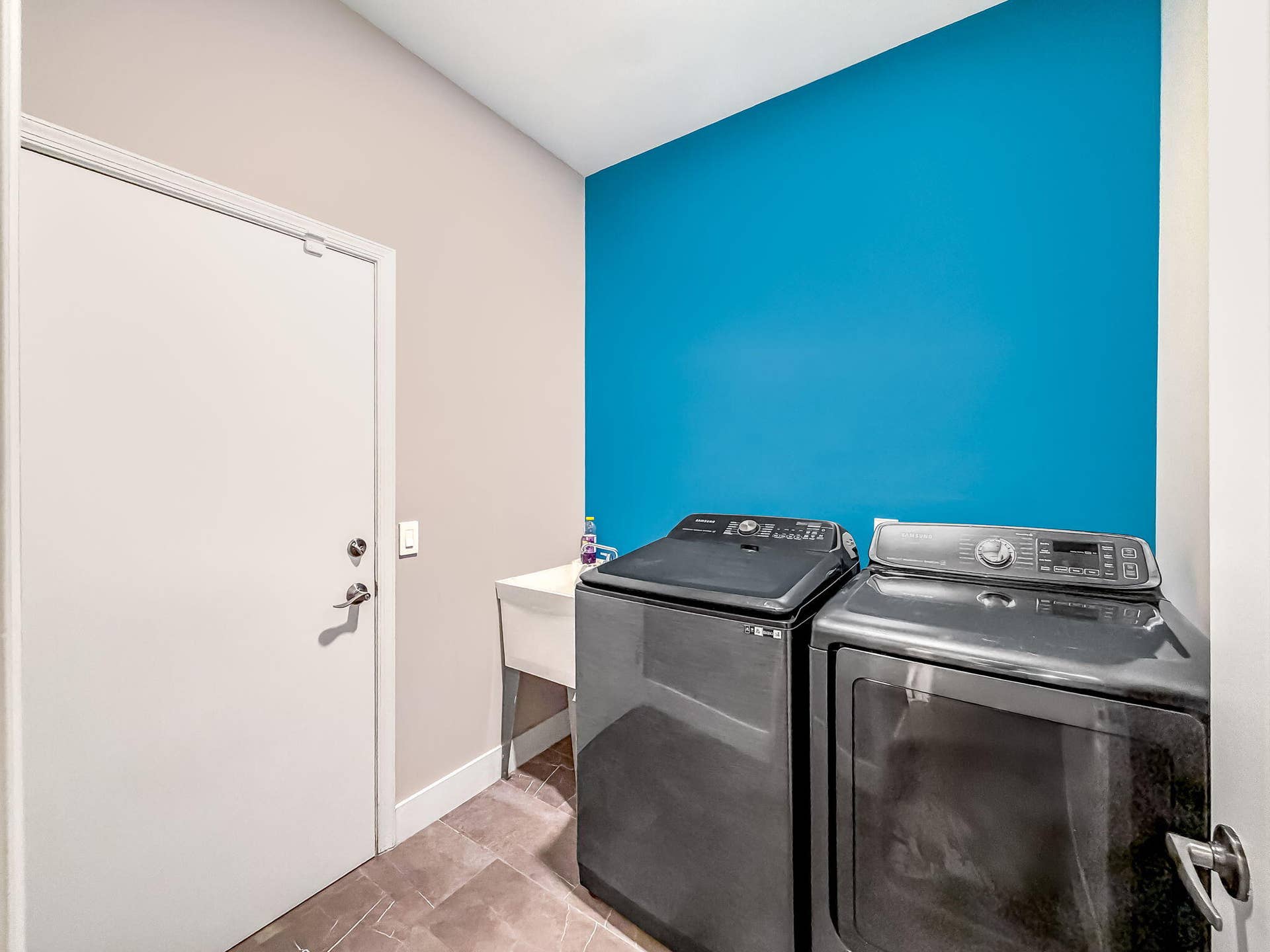 18980 CONCERTO Drive, Boca Raton, FL 33498 Laundry area featuring a utility sink, tiled flooring, and a vibrant accent wall