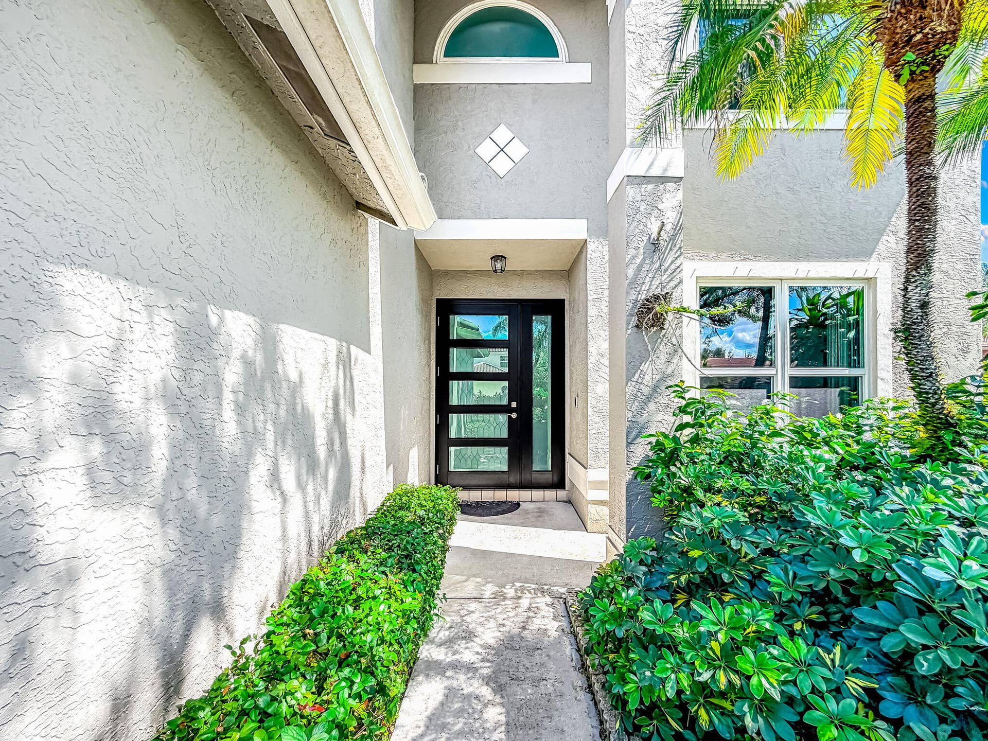 18980 CONCERTO Drive, Boca Raton, FL 33498 Modern entry door with horizontal glass panels, complemented by an arched transom window