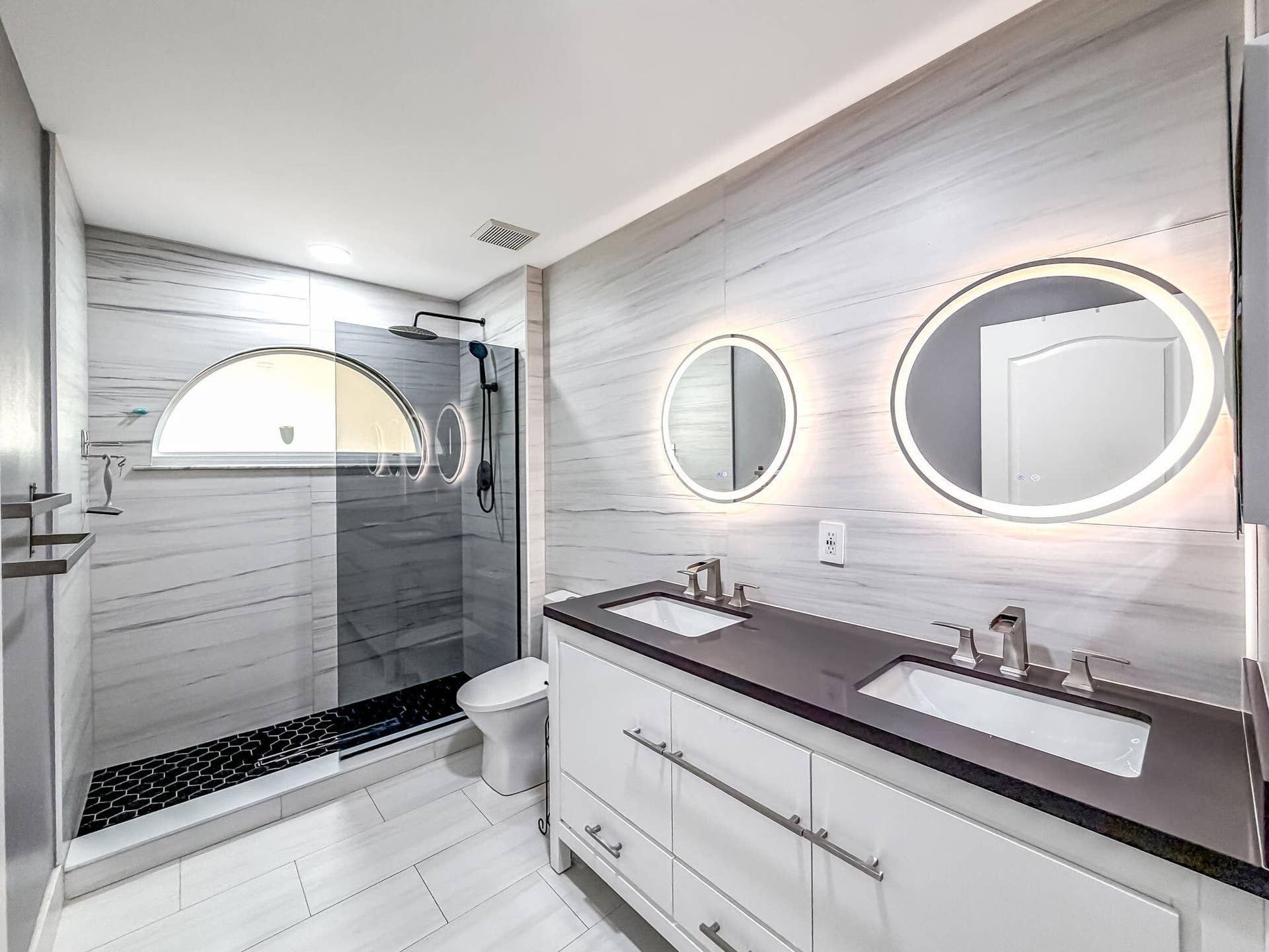 18980 CONCERTO Drive, Boca Raton, FL 33498 Dual vanity with undermount sinks, stone countertop, and illuminated round mirrors
