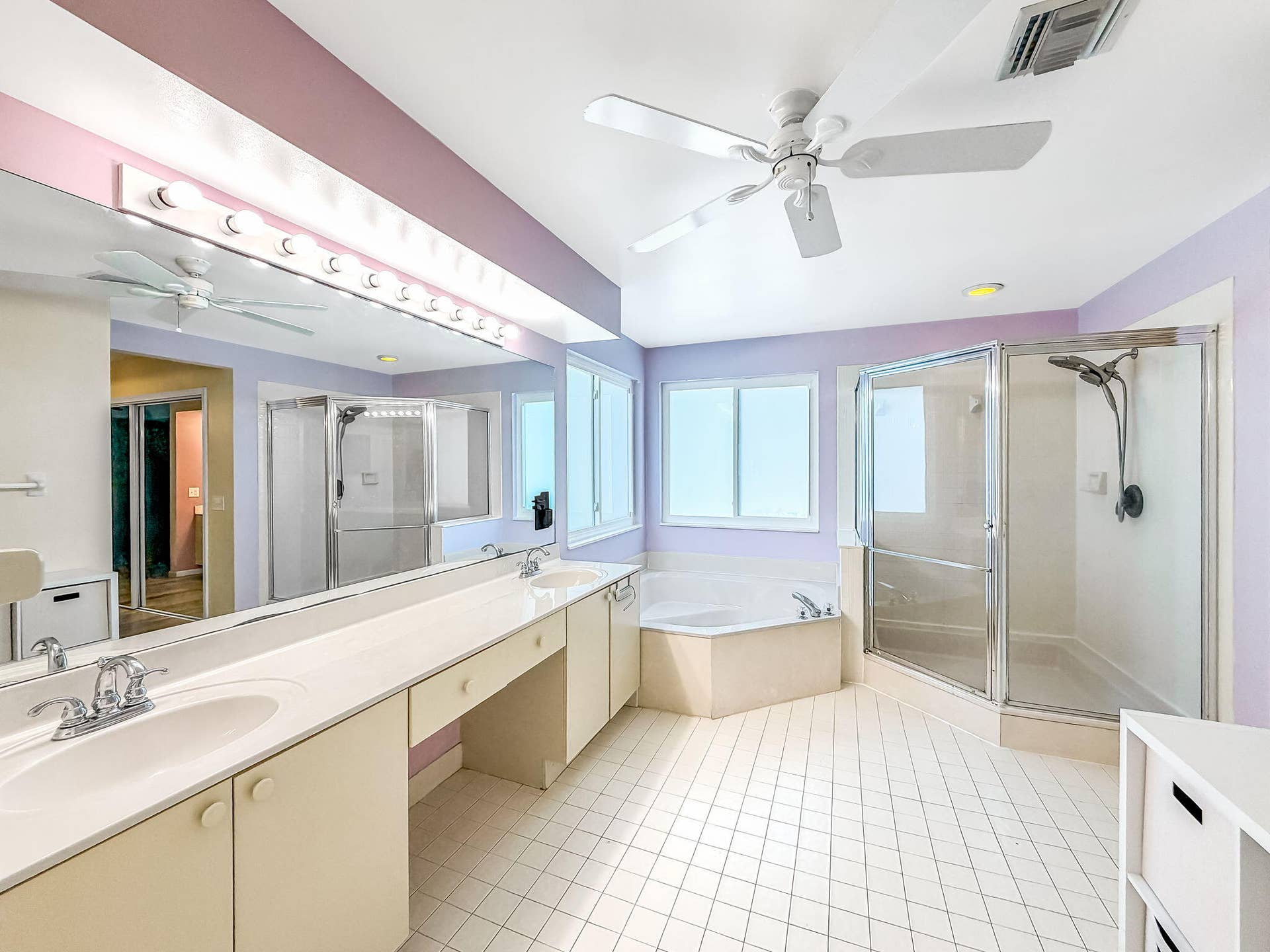 18980 CONCERTO Drive, Boca Raton, FL 33498 Dual vanity with integrated sinks, corner soaking tub, glass-enclosed shower, and ceiling fan