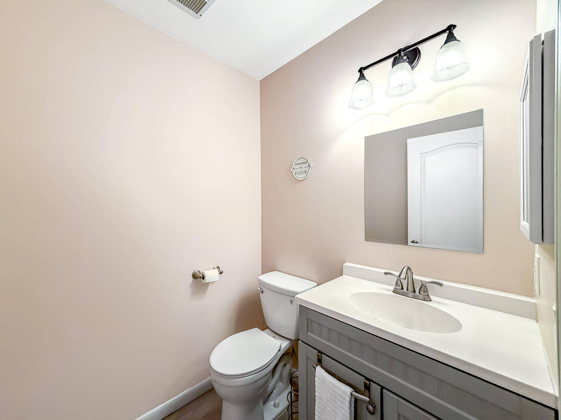 18980 CONCERTO Drive, Boca Raton, FL 33498 Gray vanity with a white countertop and integrated sink, chrome-finish faucet, and a wall-mounted mirror