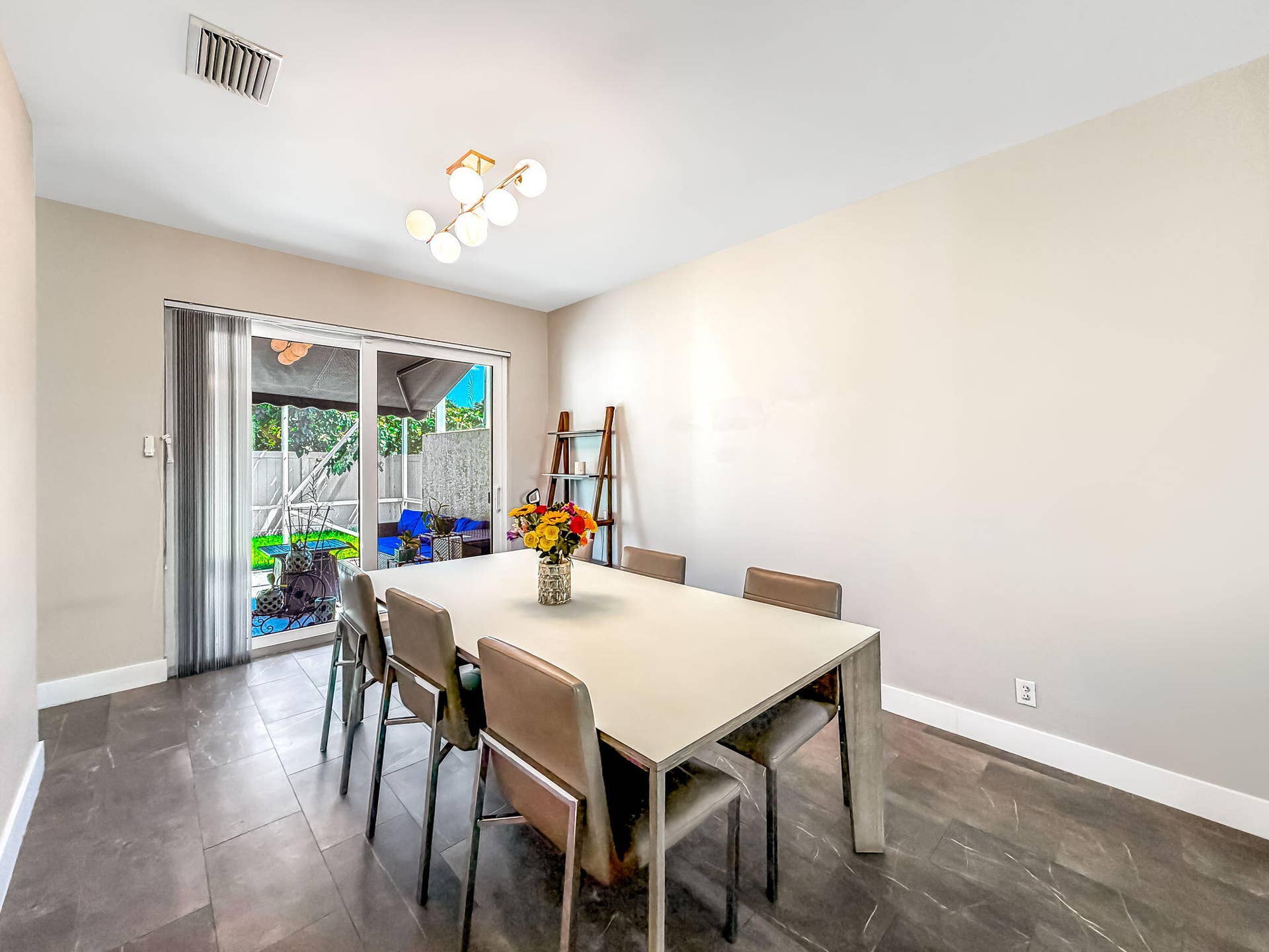 18980 CONCERTO Drive, Boca Raton, FL 33498 Sliding glass door, contemporary linear chandelier, dark tile flooring, built-in shelving, and white baseboards