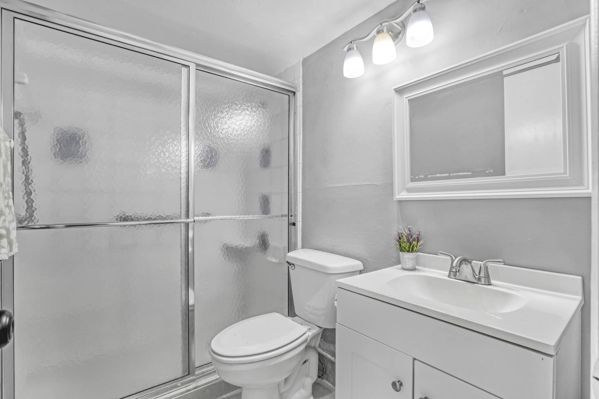 A clean, functional bathroom with a full shower and convenient vanity storage