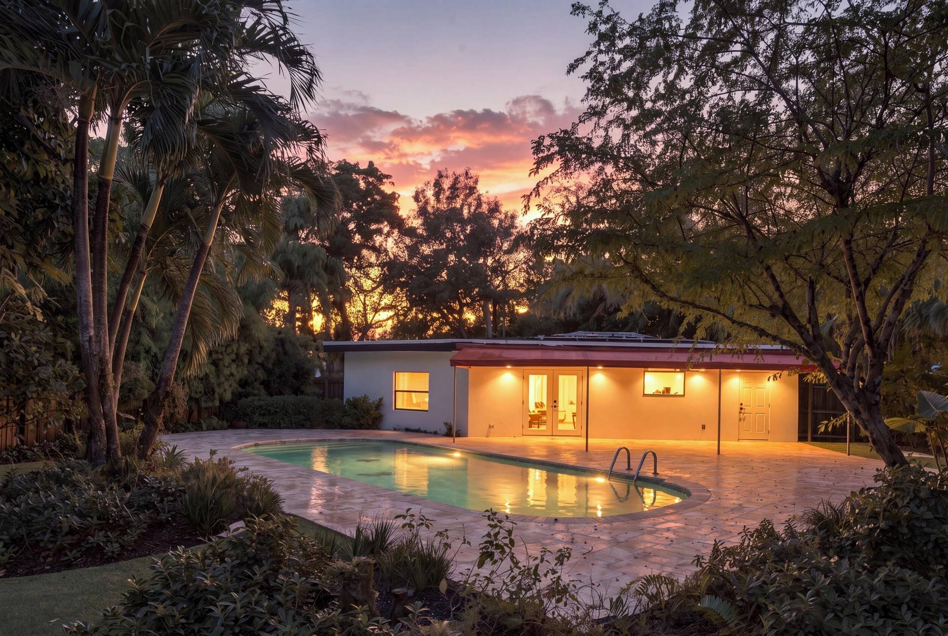 Resort-style pool with integrated steps, surrounded by a hardscape patio