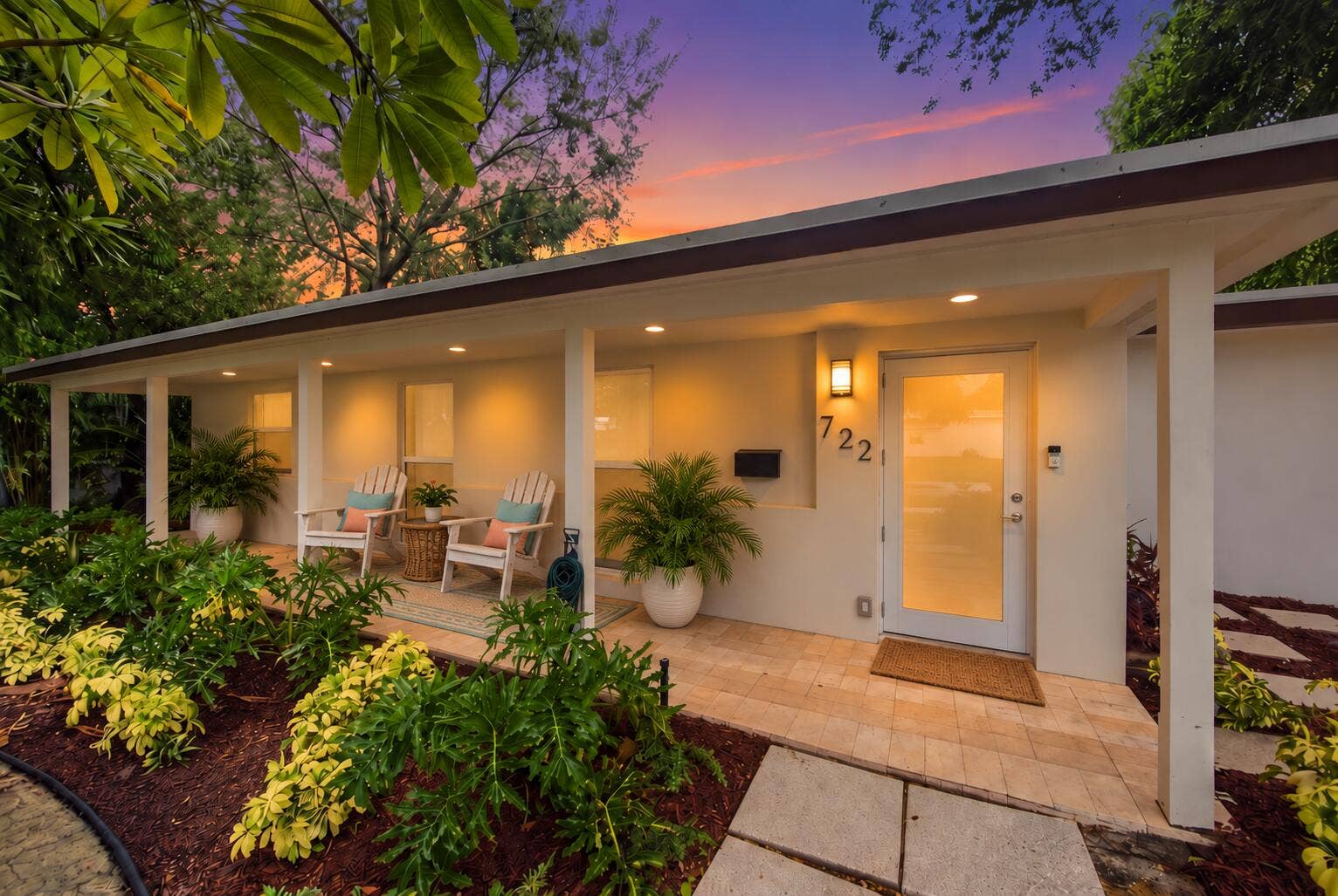 Exterior featuring a covered entry, recessed lighting, wall-mounted light fixture, decorative house numbers, and a frosted glass entry door