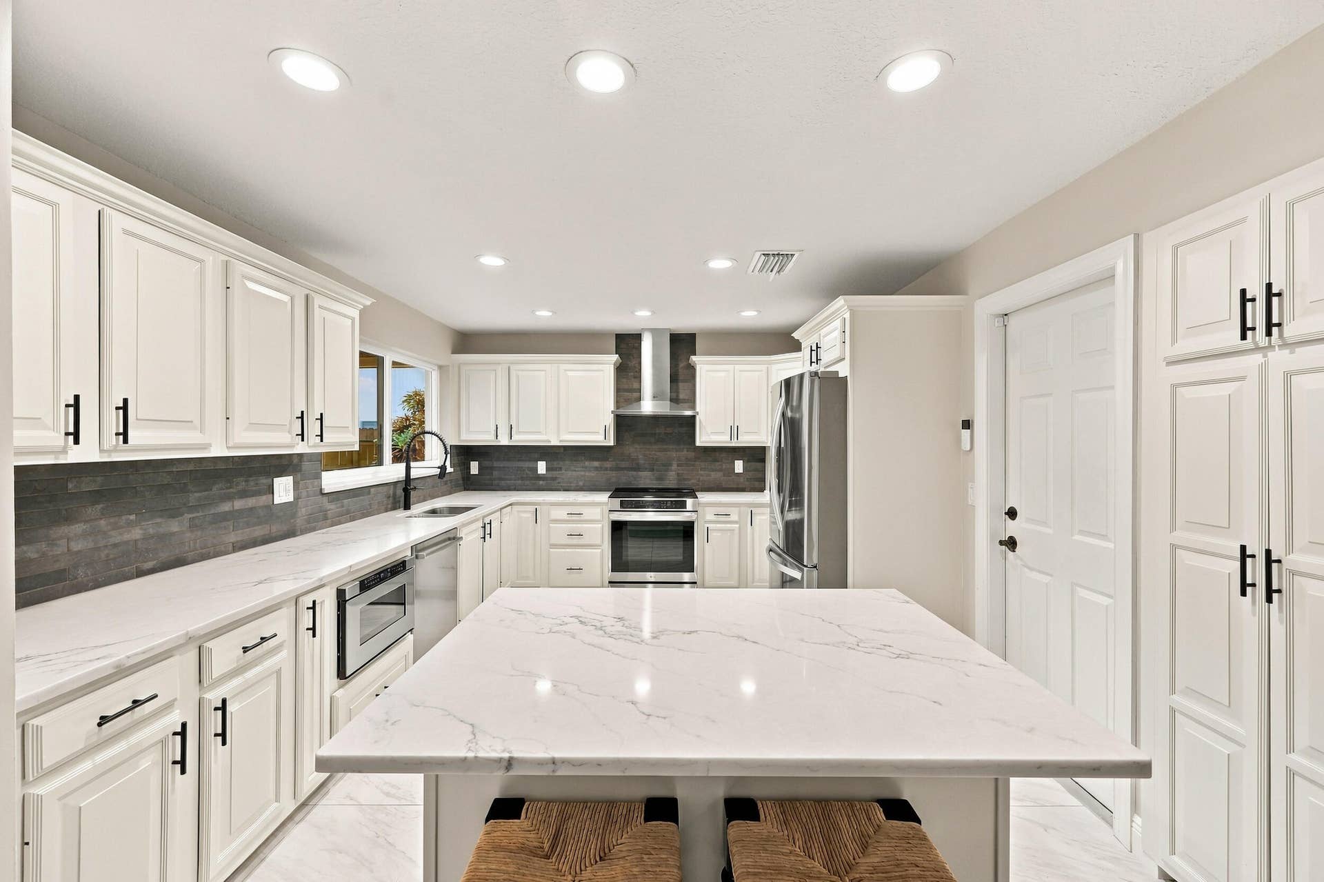 3590 Lakeview Drive, Delray Beach, FL 33445 The impeccably upgraded kitchen offers white cabinetry, quartz countertops, stainless steel appliances, and a beautiful charcoal backsplash. There is tons of storage and counter space for even the most discerning chef.