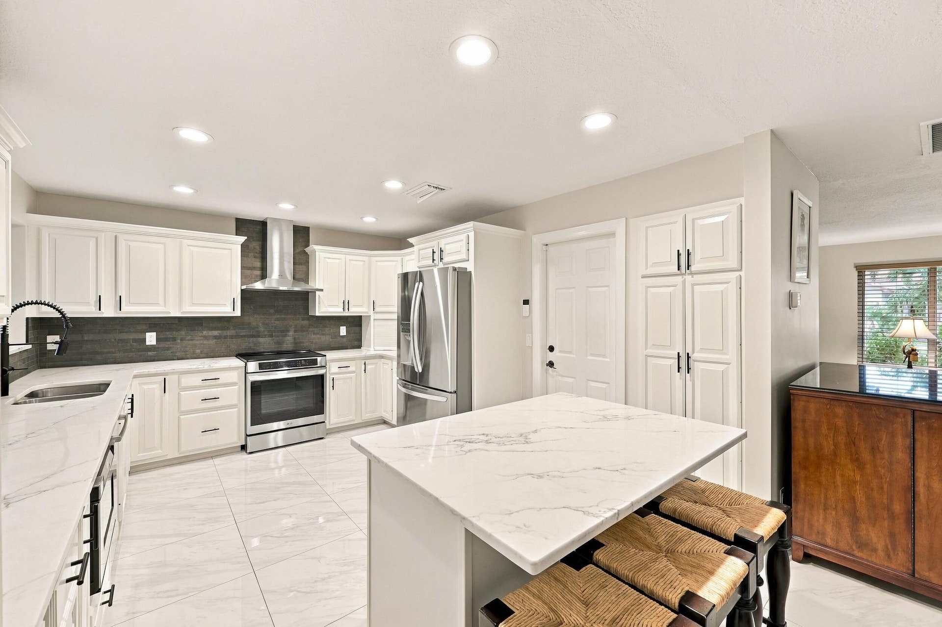 3590 Lakeview Drive, Delray Beach, FL 33445 The impeccably upgraded kitchen offers white cabinetry, quartz countertops, stainless steel appliances, and a beautiful charcoal backsplash. There is tons of storage and counter space for even the most discerning chef.