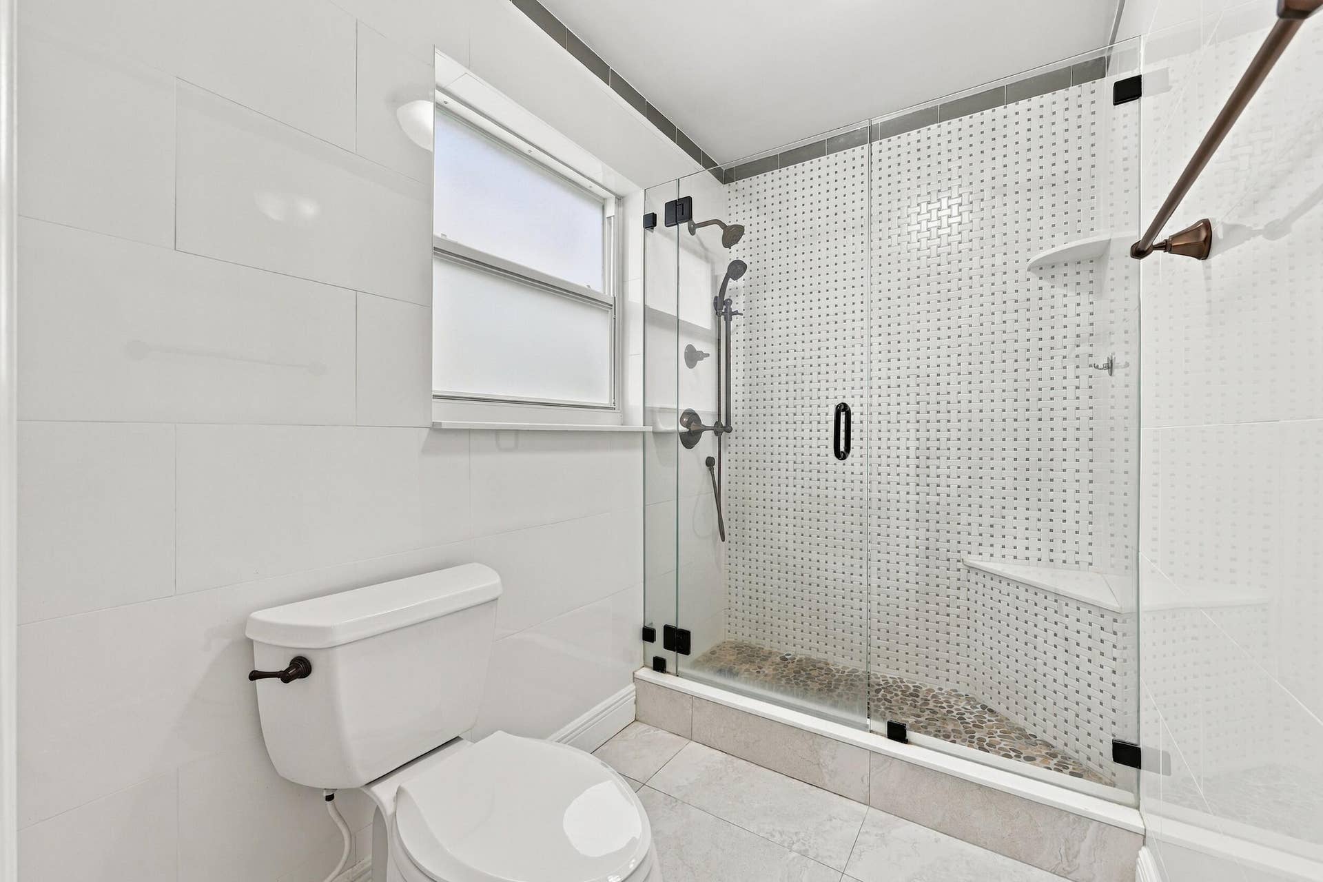 3590 Lakeview Drive, Delray Beach, FL 33445 The fully renovated primary bathroom offers dual sinks, updated cabinetry, and a brand-new frameless glass shower.