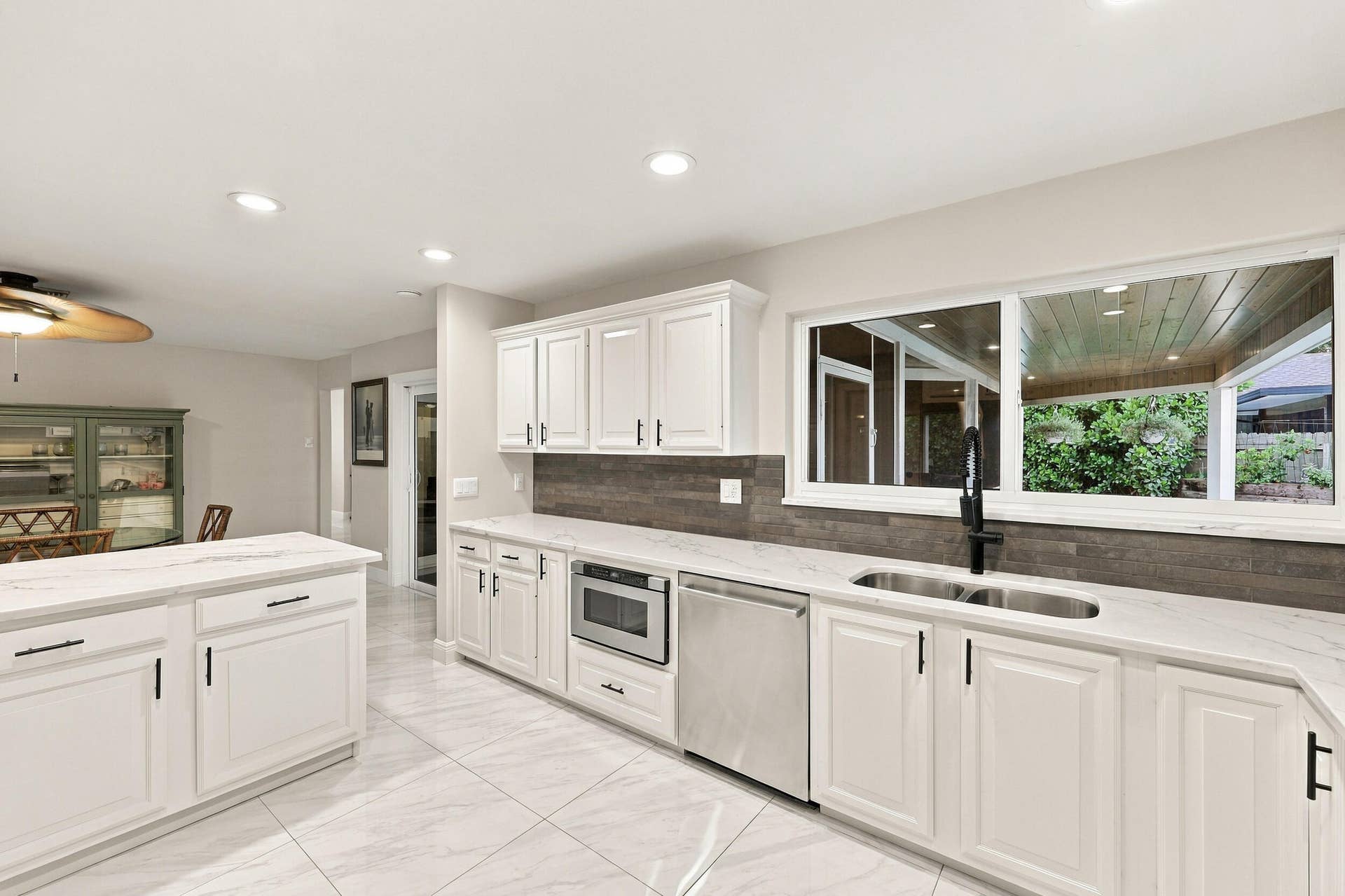 3590 Lakeview Drive, Delray Beach, FL 33445 From the kitchen sink, you can admire the resort-style pool, spacious backyard, and 900-square-foot covered and screened-in patio.