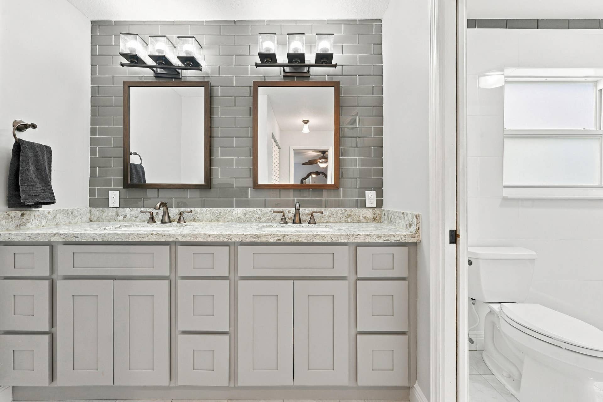 3590 Lakeview Drive, Delray Beach, FL 33445 The fully renovated primary bathroom offers dual sinks, updated cabinetry, and a brand-new frameless glass shower.