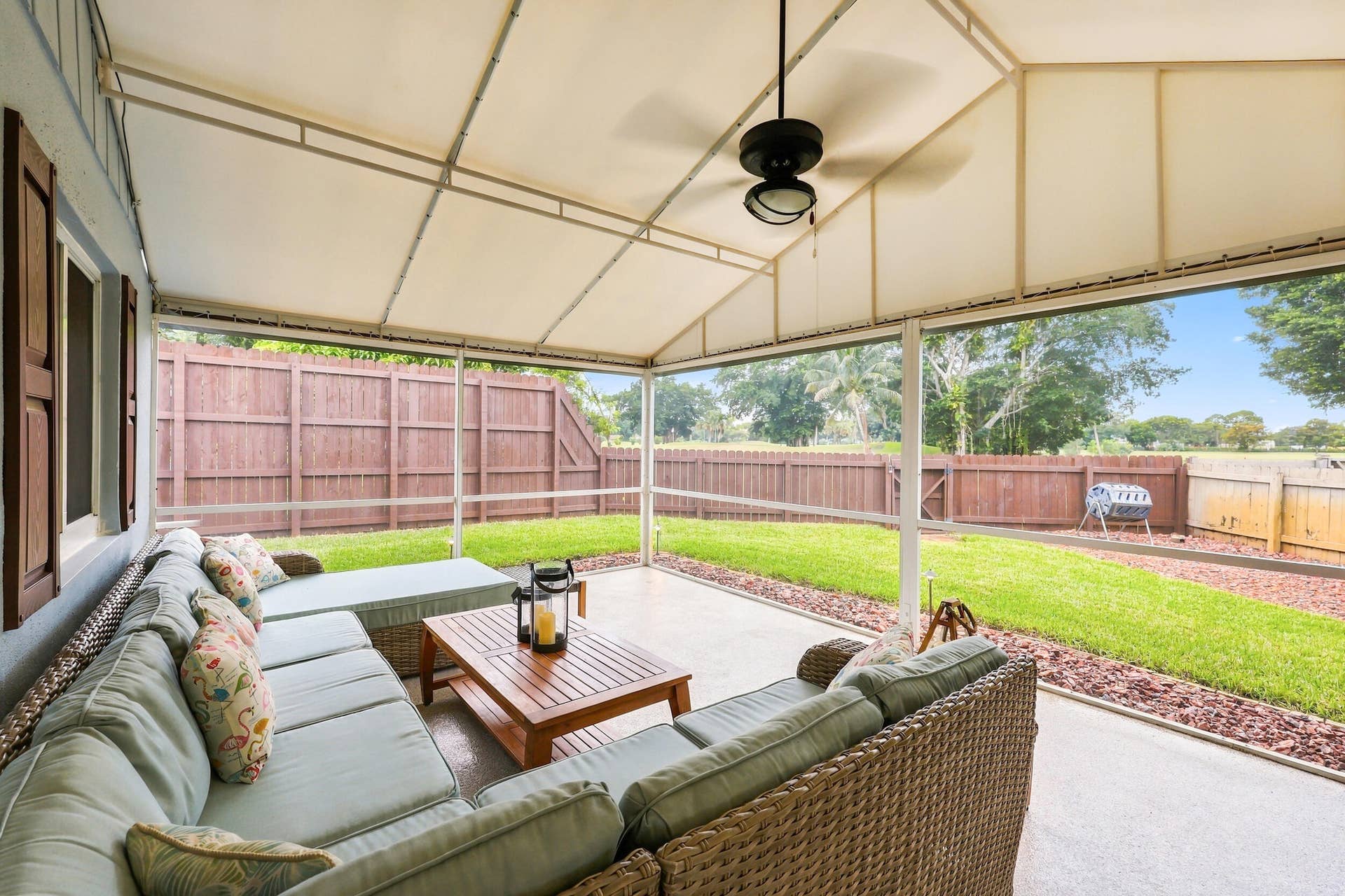 3590 Lakeview Drive, Delray Beach, FL 33445 A living room outside is highlighted by vaulted ceilings, a privacy fence, views of Lakeview Golf Course, and a versatile area to entertain.