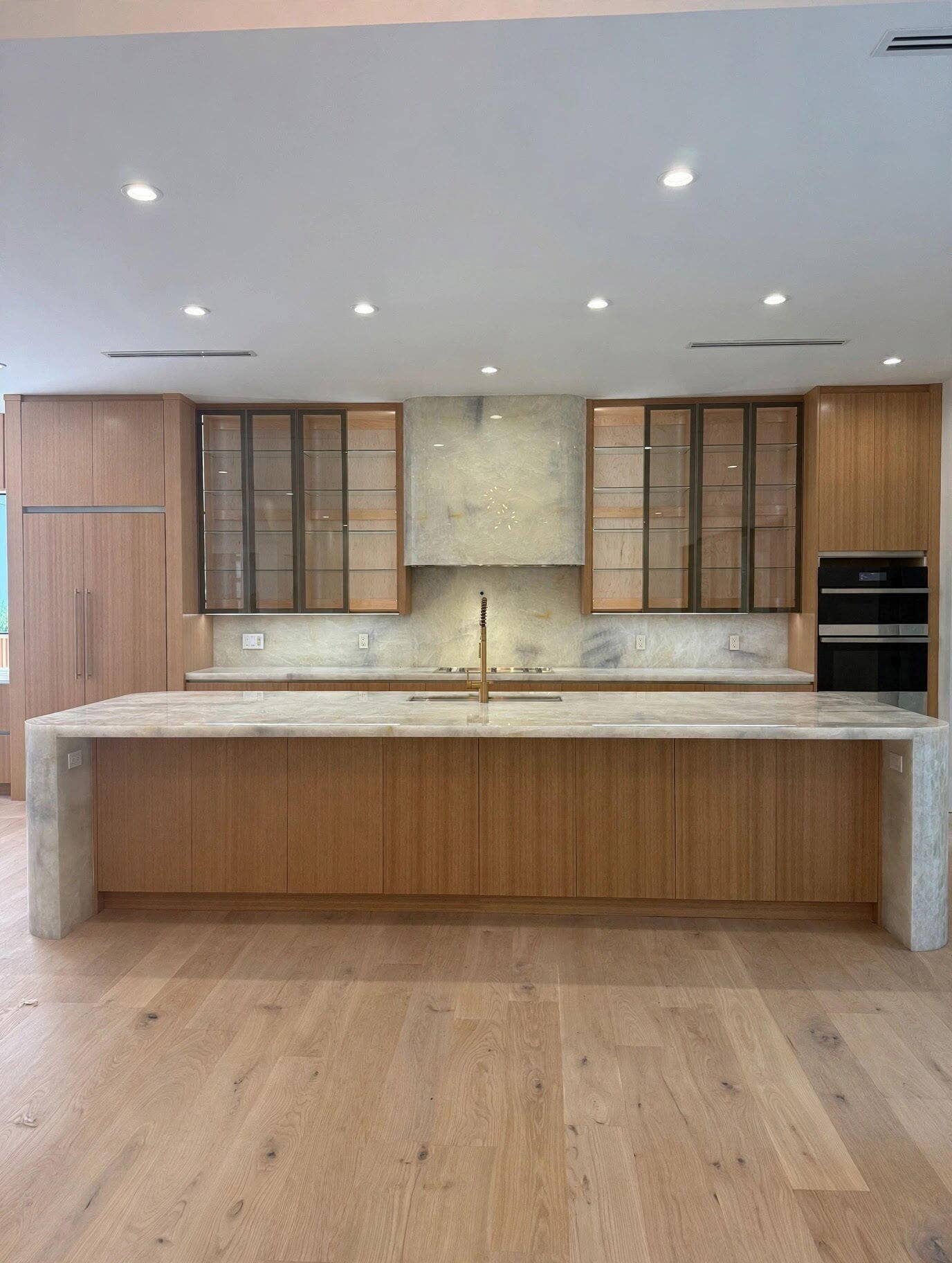 1109 PROSPERITY VILLAGE Drive, North Palm Beach, FL 33410 Wide plank wood-finish flooring, recessed lighting, and a kitchen island with stone waterfall edges