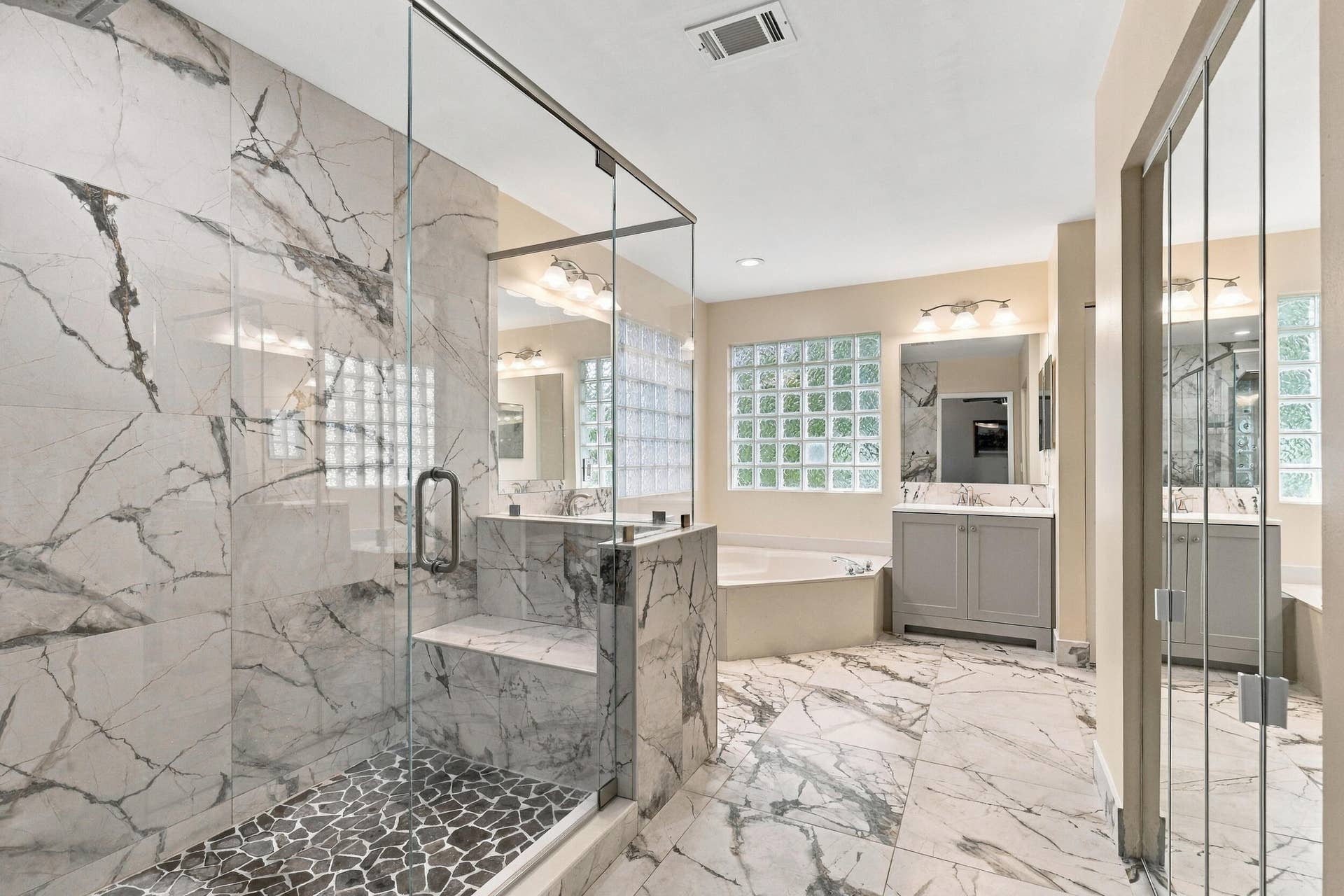 1434 Artimino Lane, Boynton Beach, FL 33436 The primary bathroom rivals any five-star spa with a dramatic and elegant, frameless, marble glass shower matching the floors of the bathroom.
