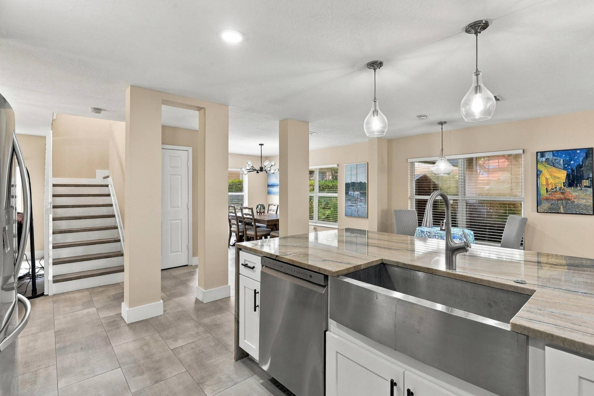 1434 Artimino Lane, Boynton Beach, FL 33436 The heart of the home is the exquisite renovated kitchen, featuring white Shaker style cabinetry, stunning quartzite countertops and backsplash, stainless steel appliances, designer lighting, abundant storage, and an oversized island that creates an impressive centerpiece for everyday living and entertaining. The open layout flows effortlessly into the main living areas and breakfast nook, while a separate dining space provides plenty of room for gatherings.