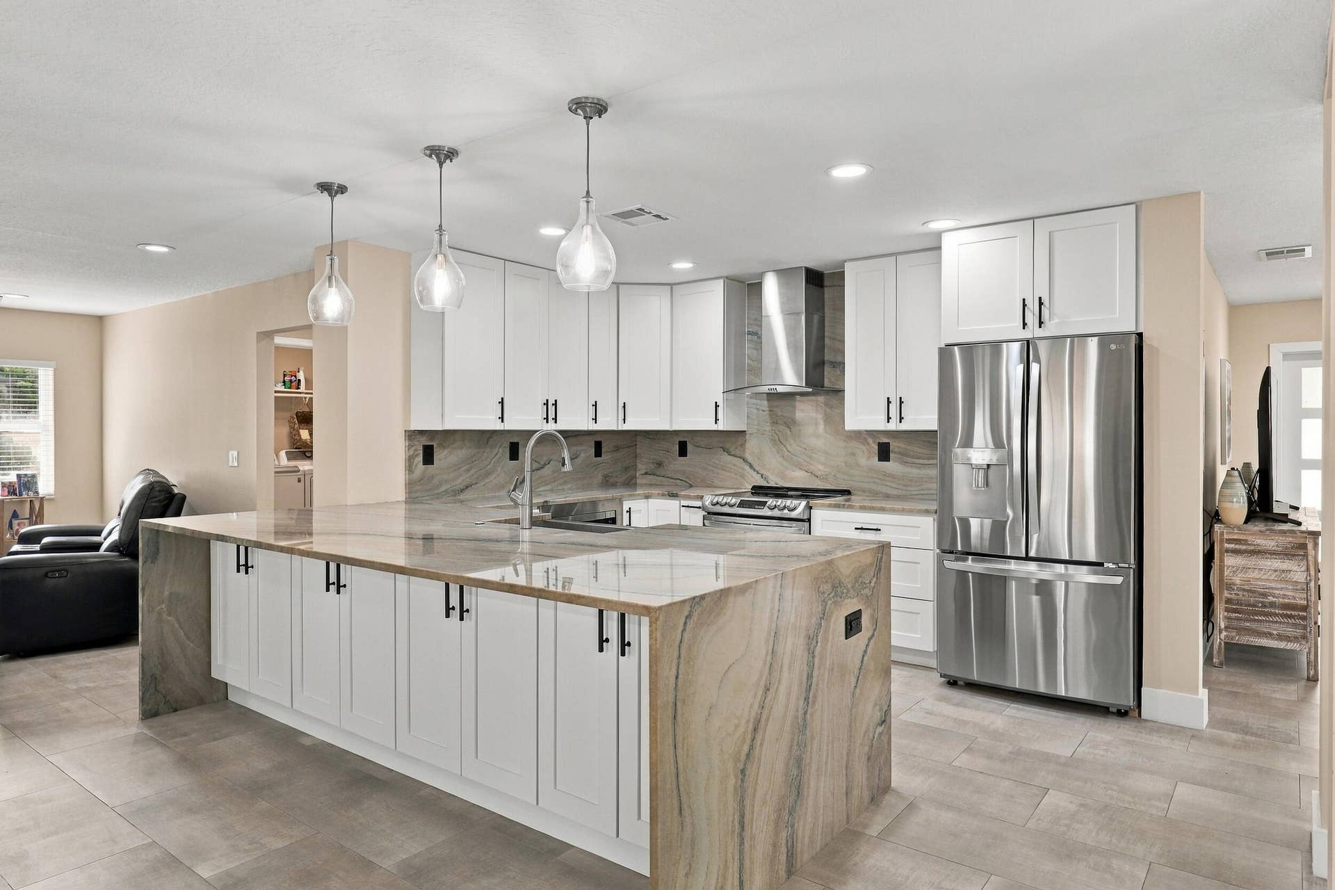 1434 Artimino Lane, Boynton Beach, FL 33436 The heart of the home is the exquisite renovated kitchen, featuring white Shaker style cabinetry, stunning quartzite countertops and backsplash, stainless steel appliances, designer lighting, abundant storage, and an oversized island that creates an impressive centerpiece for everyday living and entertaining. The open layout flows effortlessly into the main living areas and breakfast nook, while a separate dining space provides plenty of room for gatherings.