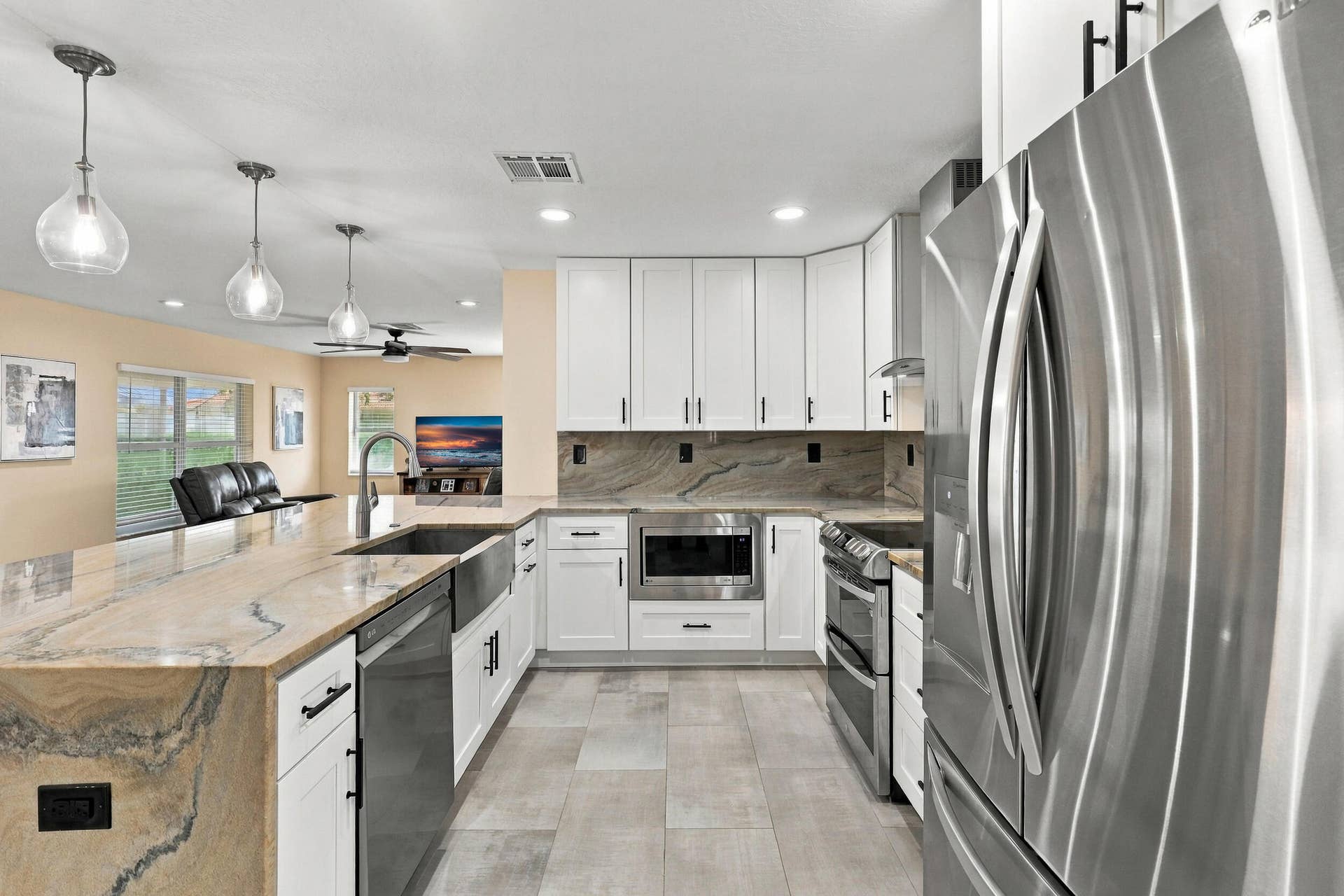 1434 Artimino Lane, Boynton Beach, FL 33436 The heart of the home is the exquisite renovated kitchen, featuring white Shaker style cabinetry, stunning quartzite countertops and backsplash, stainless steel appliances, designer lighting, abundant storage, and an oversized island that creates an impressive centerpiece for everyday living and entertaining. The open layout flows effortlessly into the main living areas and breakfast nook, while a separate dining space provides plenty of room for gatherings.