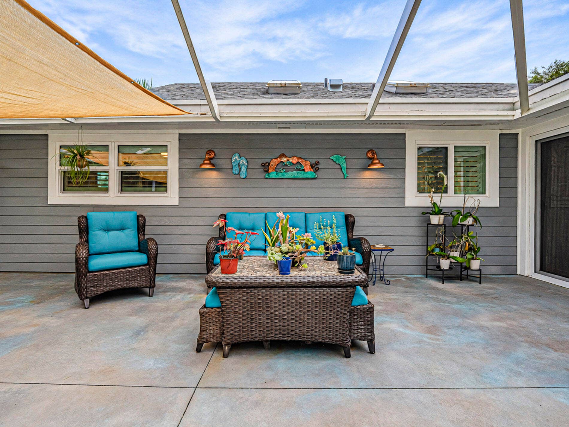 215 8TH Terrace, Vero Beach, FL 32962 Expansive patio area featuring a patterned concrete surface, horizontal siding, and a shade sail