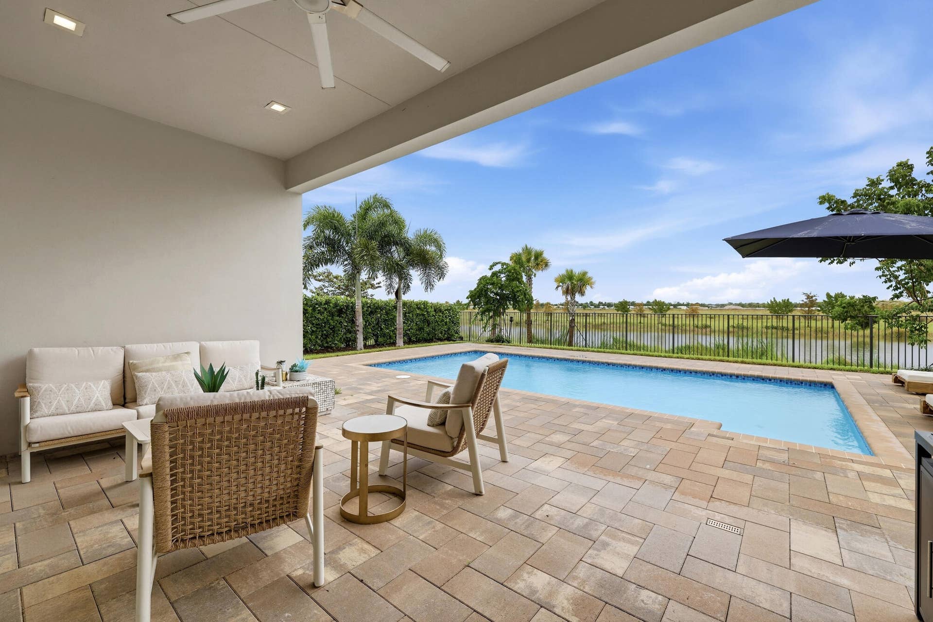 Covered patio with recessed lighting and a ceiling fan, opening to a paver deck