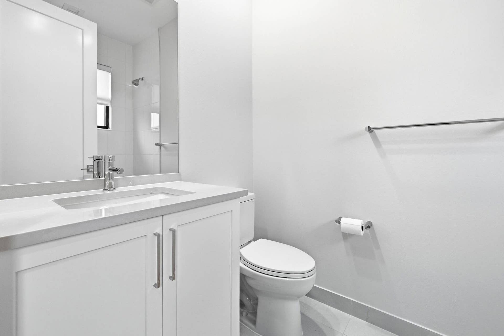 White vanity with an integrated sink, polished chrome faucet, and coordinating hardware