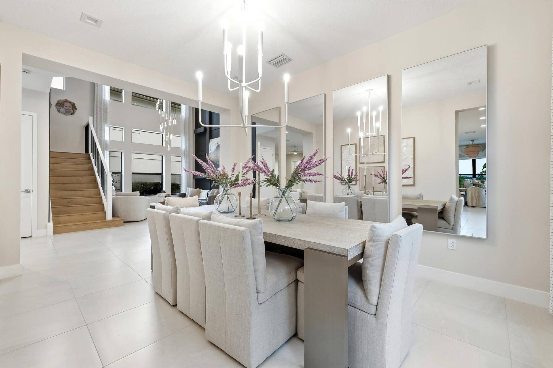 Open-concept dining area featuring a light-toned dining table and white tile flooring