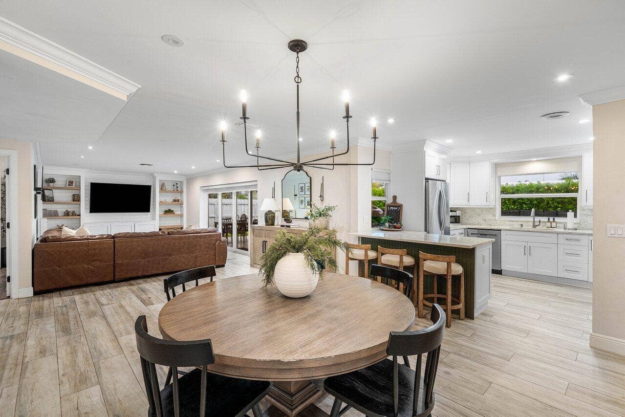 979 SW 13TH Drive, Boca Raton, FL 33486 A chandelier anchors the dining area, with the kitchen and living room close by.