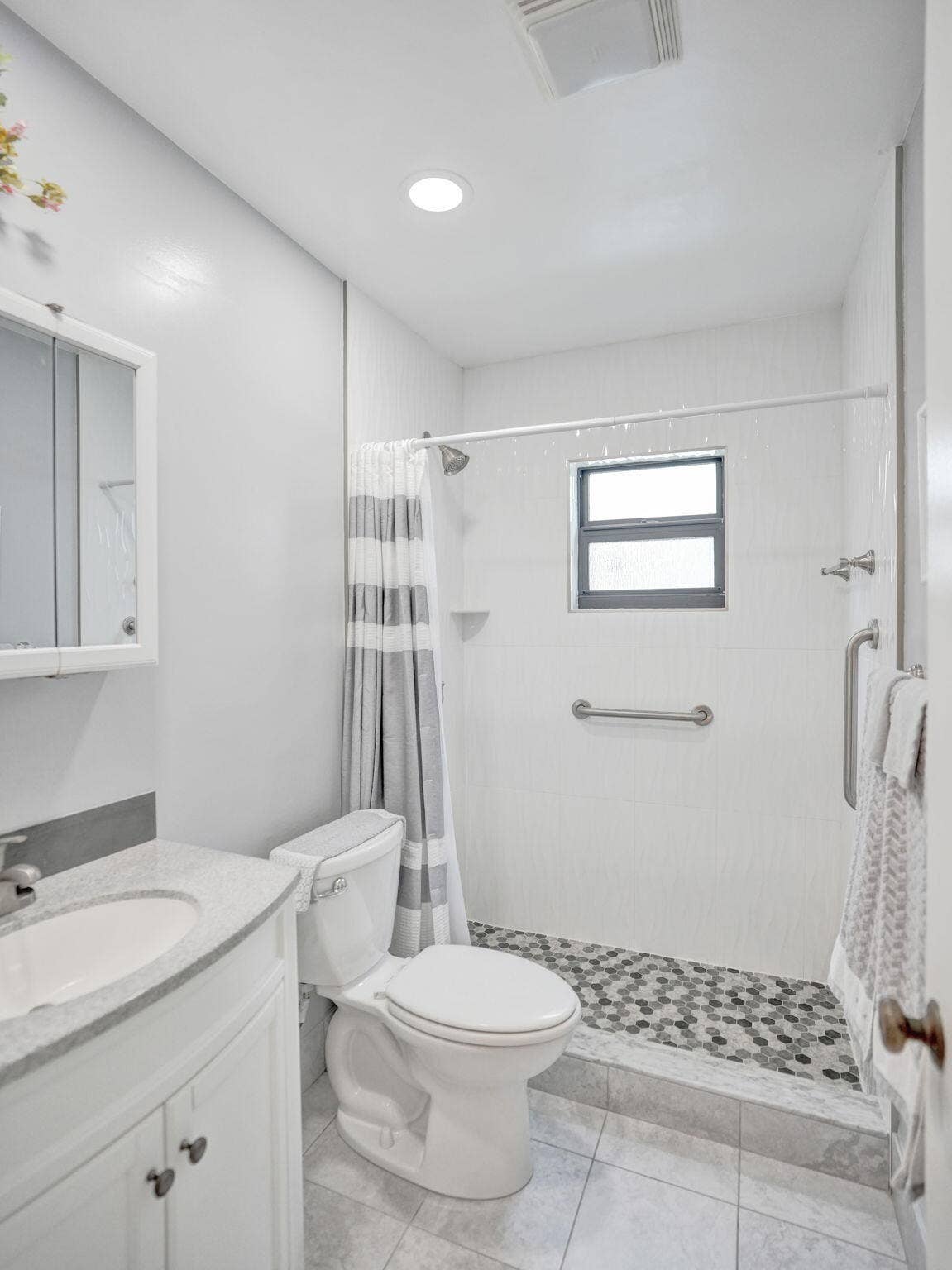 2085 SW 15th Place, Deerfield Beach, FL 33442 Bathroom featuring a vanity with an integrated sink and light-toned countertop, a toilet, and a walk-in shower with mosaic tile flooring
