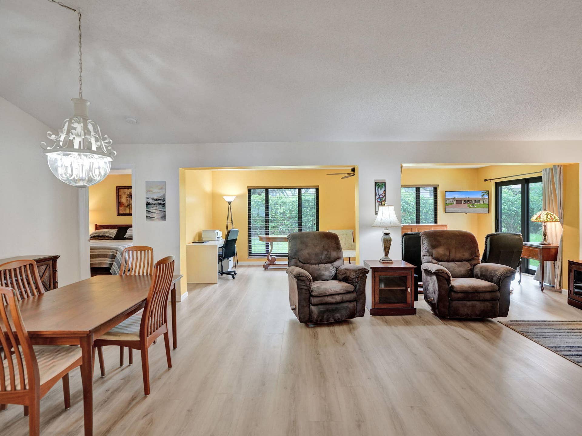 2085 SW 15th Place, Deerfield Beach, FL 33442 Light wood-finish flooring throughout, featuring a dining area with a chandelier