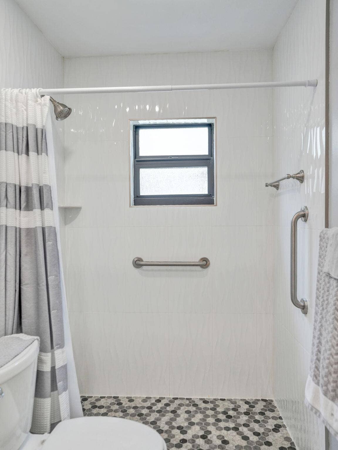 2085 SW 15th Place, Deerfield Beach, FL 33442 Shower with white tile surround, mosaic tile flooring, and integrated window