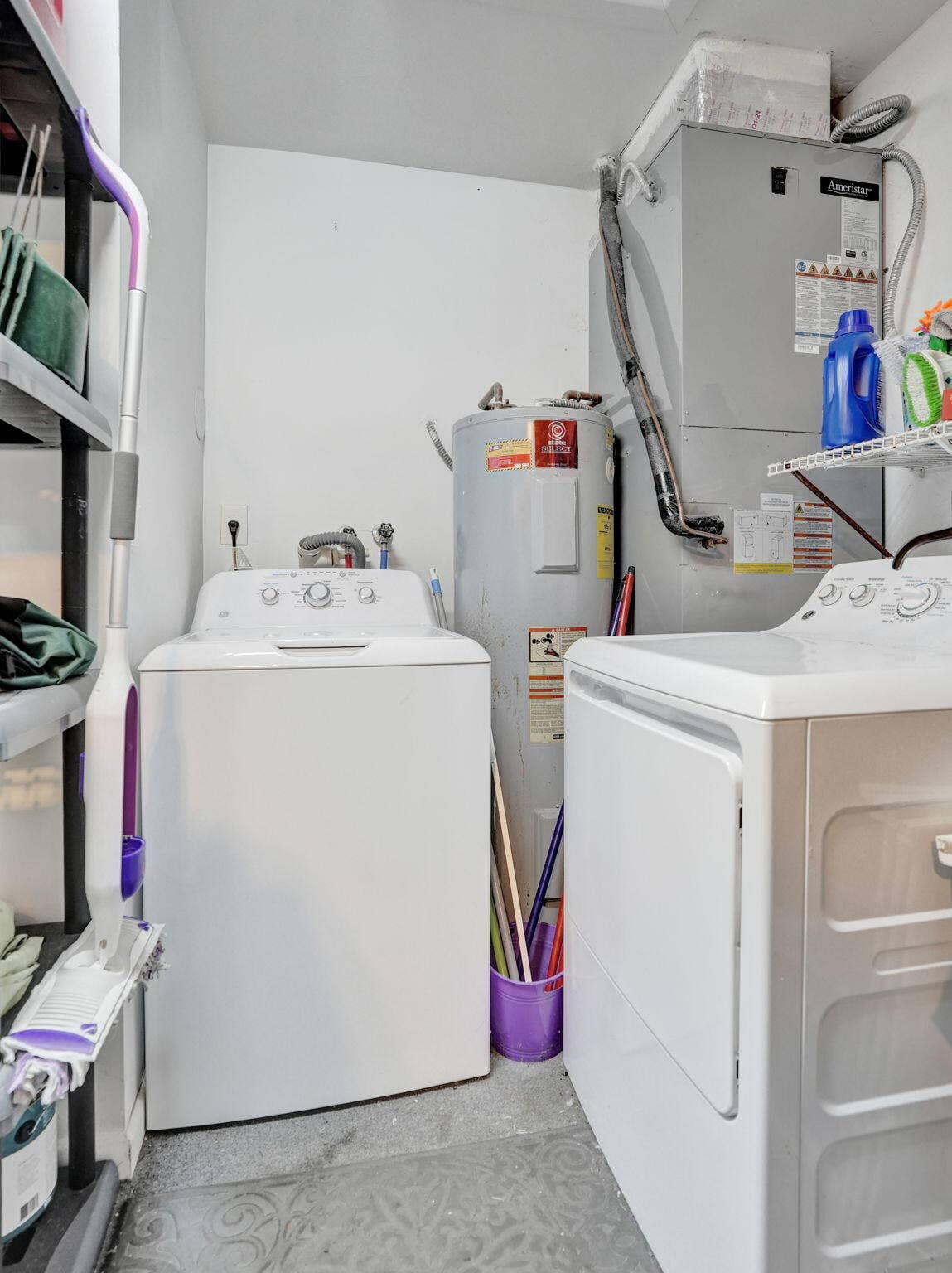 2085 SW 15th Place, Deerfield Beach, FL 33442 Dedicated laundry area on a raised platform at the back of the garage, featuring a washer, dryer, and shelving for storage.