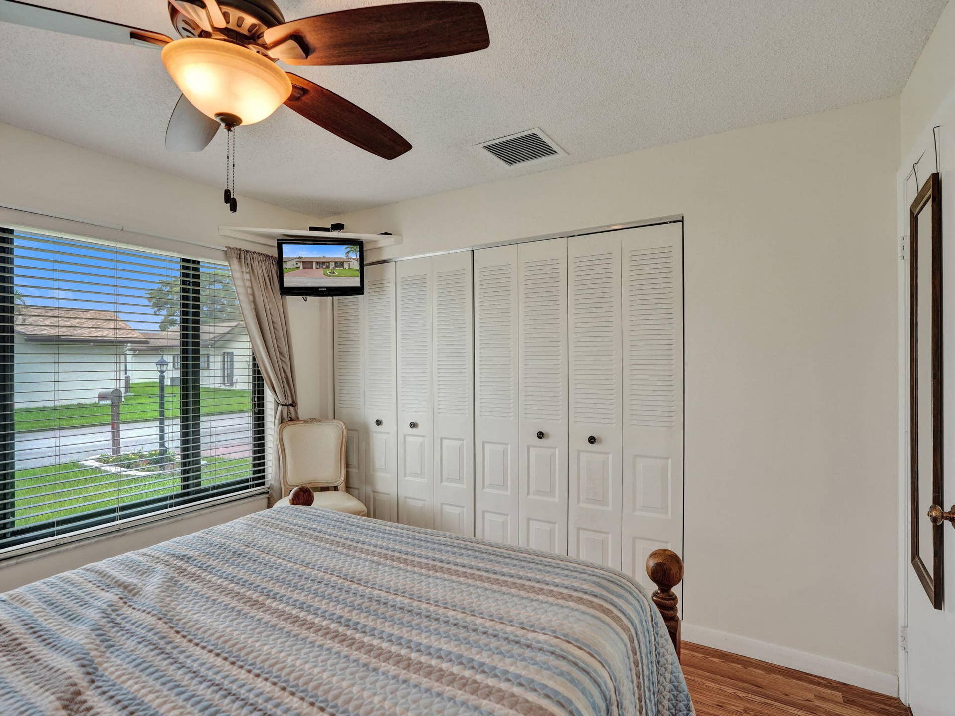 2085 SW 15th Place, Deerfield Beach, FL 33442 Wood-finish flooring, ceiling fan with integrated lighting, window with blinds, and white bi-fold closet doors