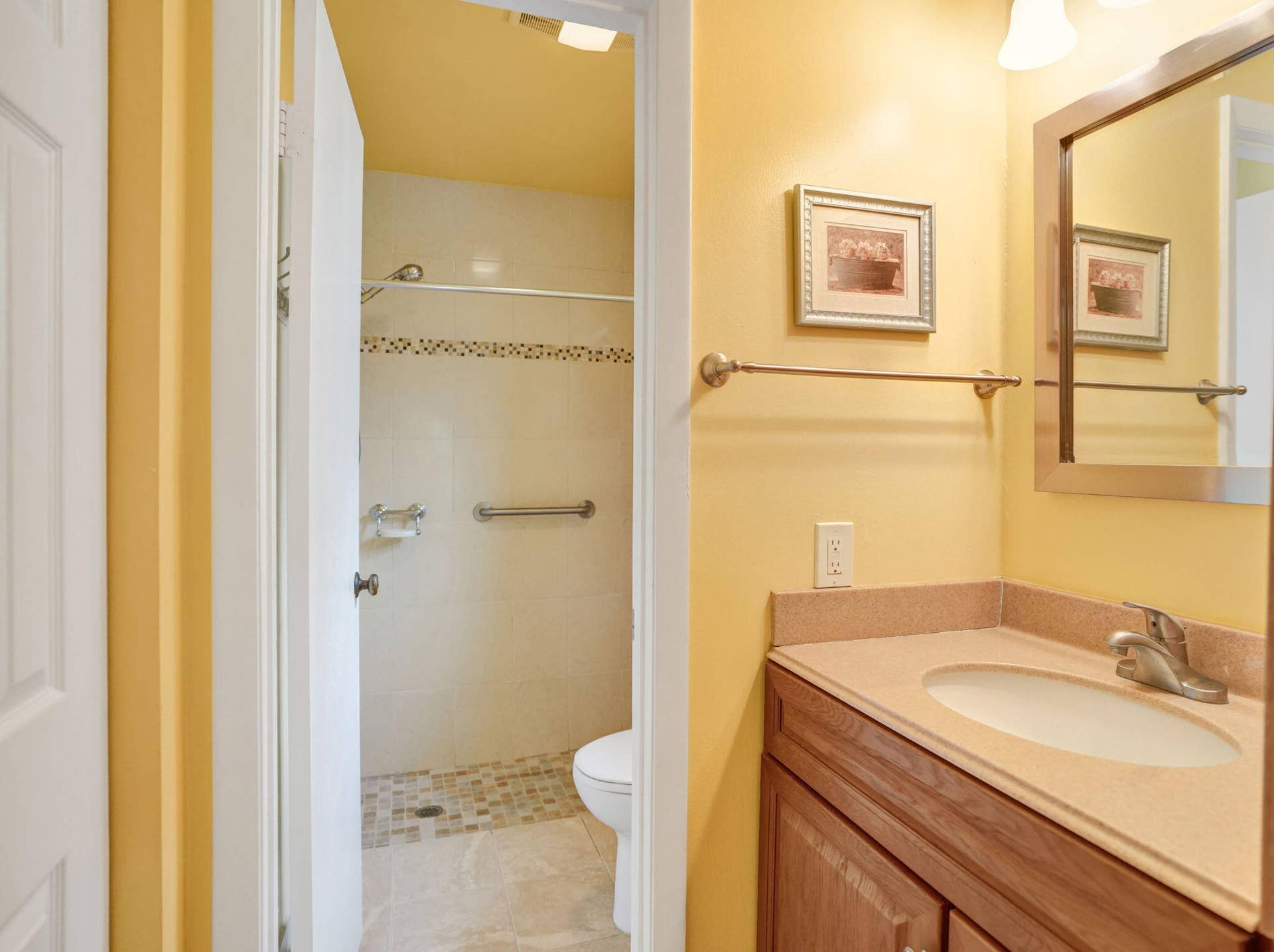 2085 SW 15th Place, Deerfield Beach, FL 33442 Primary bathroom vanity with raised-panel cabinetry, drawers, a tall storage cabinet, and a framed mirror, located outside the separate toilet and shower room.