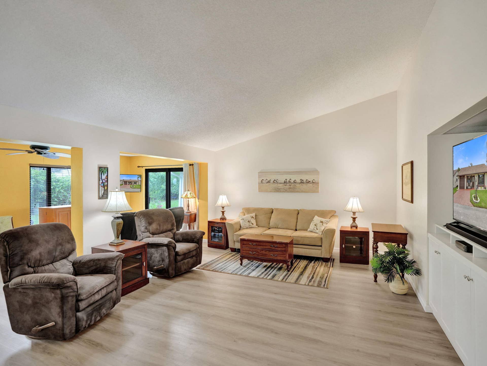 2085 SW 15th Place, Deerfield Beach, FL 33442 Vaulted ceilings, wood-finish flooring, built-in media cabinetry, and an open-concept layout