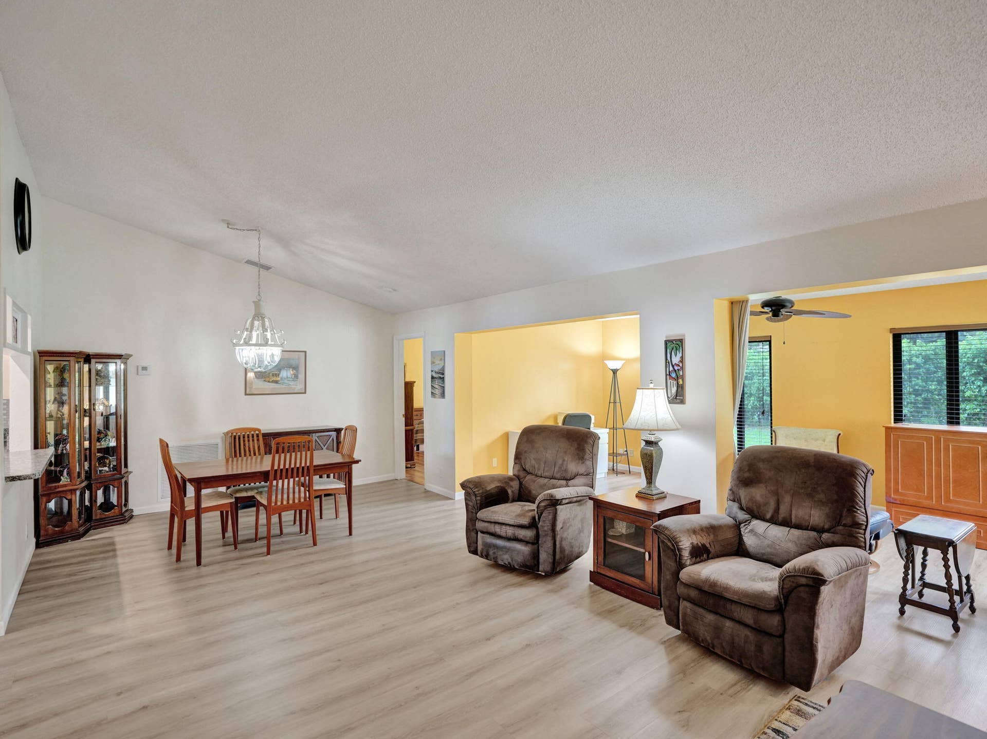 2085 SW 15th Place, Deerfield Beach, FL 33442 Vaulted ceilings, wood-finish flooring, and a chandelier over the dining area