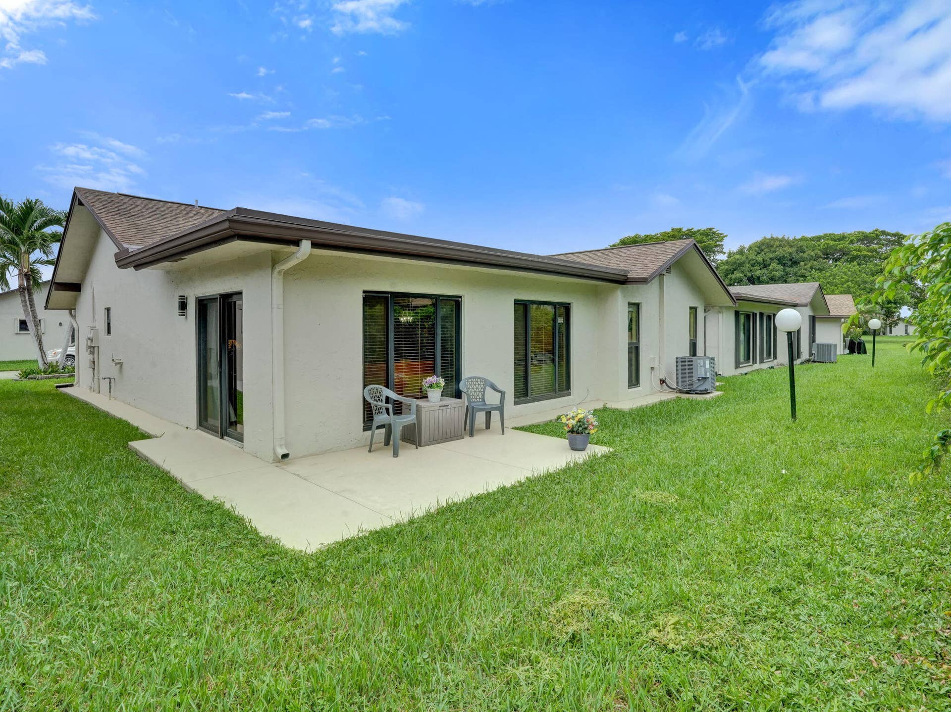 2085 SW 15th Place, Deerfield Beach, FL 33442 Exterior patio with concrete surface, multiple windows, and a sliding glass door