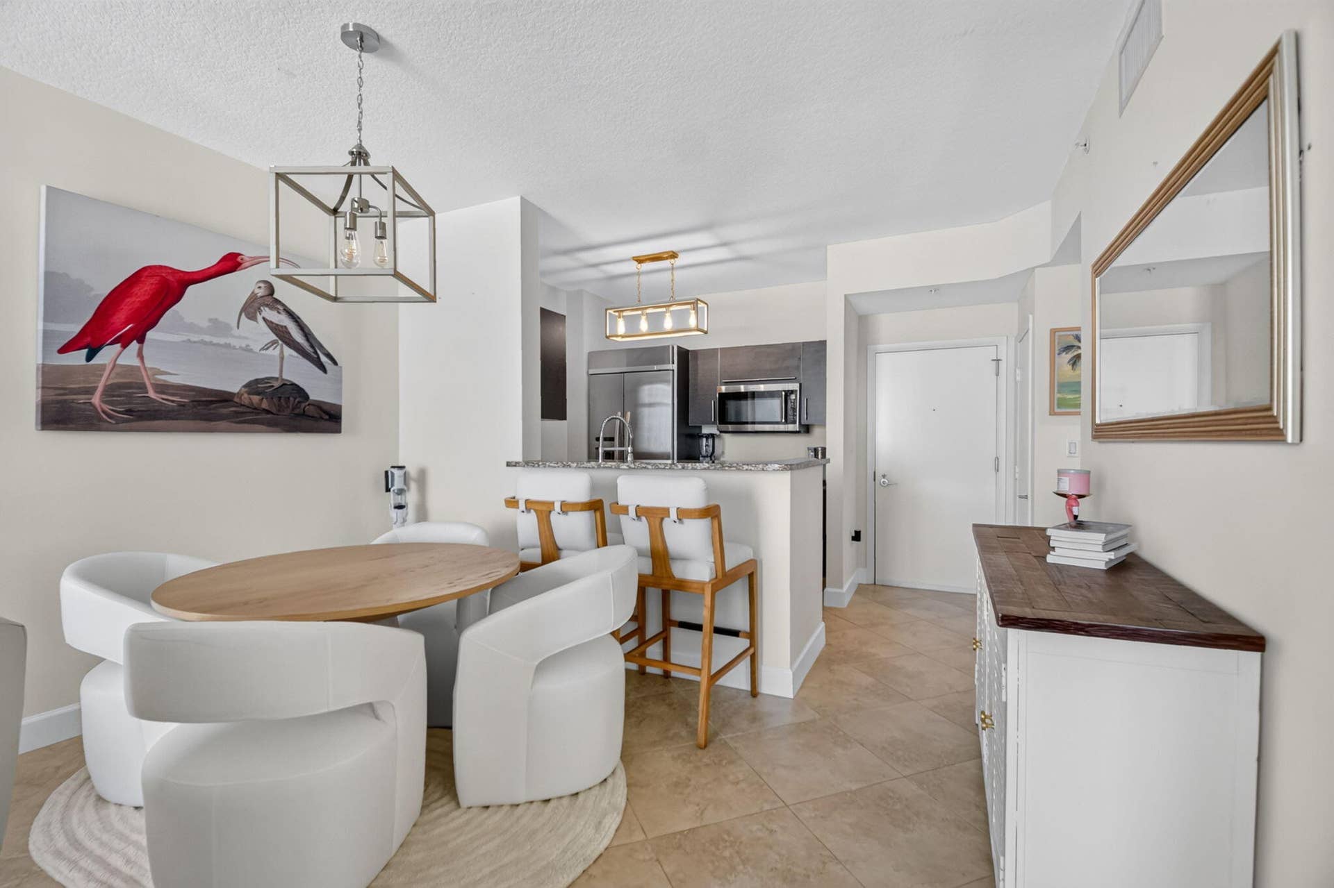 550 OKEECHOBEE Boulevard, #1618, West Palm Beach, West Palm Beach, FL 33401 Open-concept living space with tile flooring, a kitchen featuring stainless steel appliances and a breakfast bar, and a dining area illuminated by a geometric pendant light