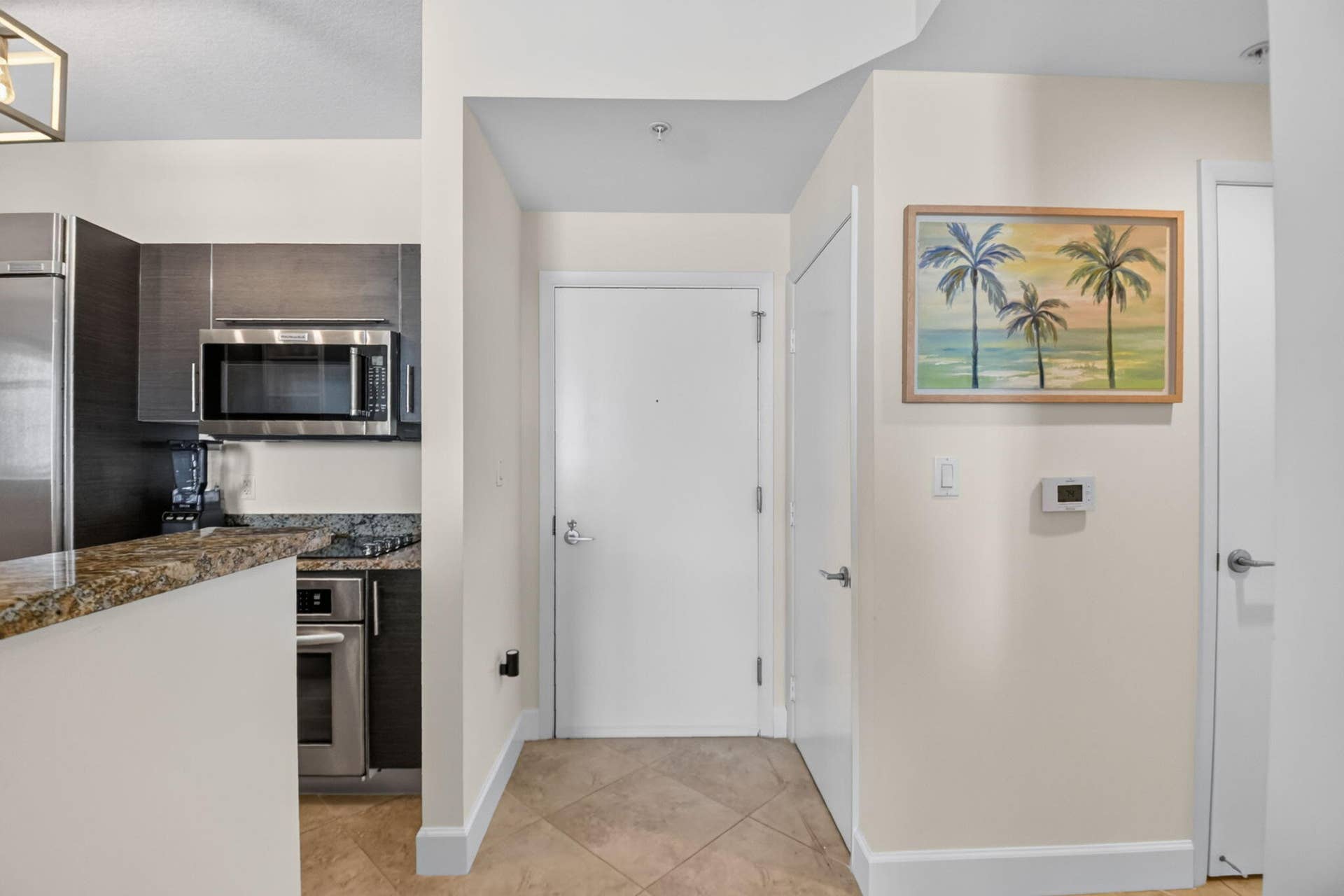 550 OKEECHOBEE Boulevard, #1618, West Palm Beach, West Palm Beach, FL 33401 Kitchen counter with natural stone surface, stainless steel appliances, and dark wood-finish cabinetry
