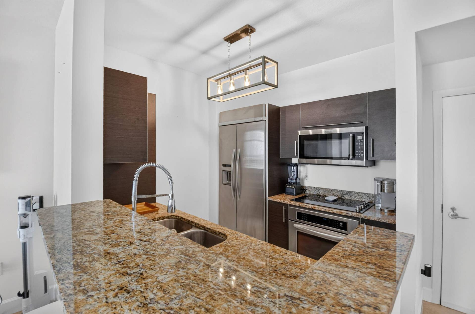 550 OKEECHOBEE Boulevard, #1618, West Palm Beach, West Palm Beach, FL 33401 Kitchen featuring granite countertops, stainless steel appliances, dark wood-finish cabinetry, and a rectangular pendant light fixture