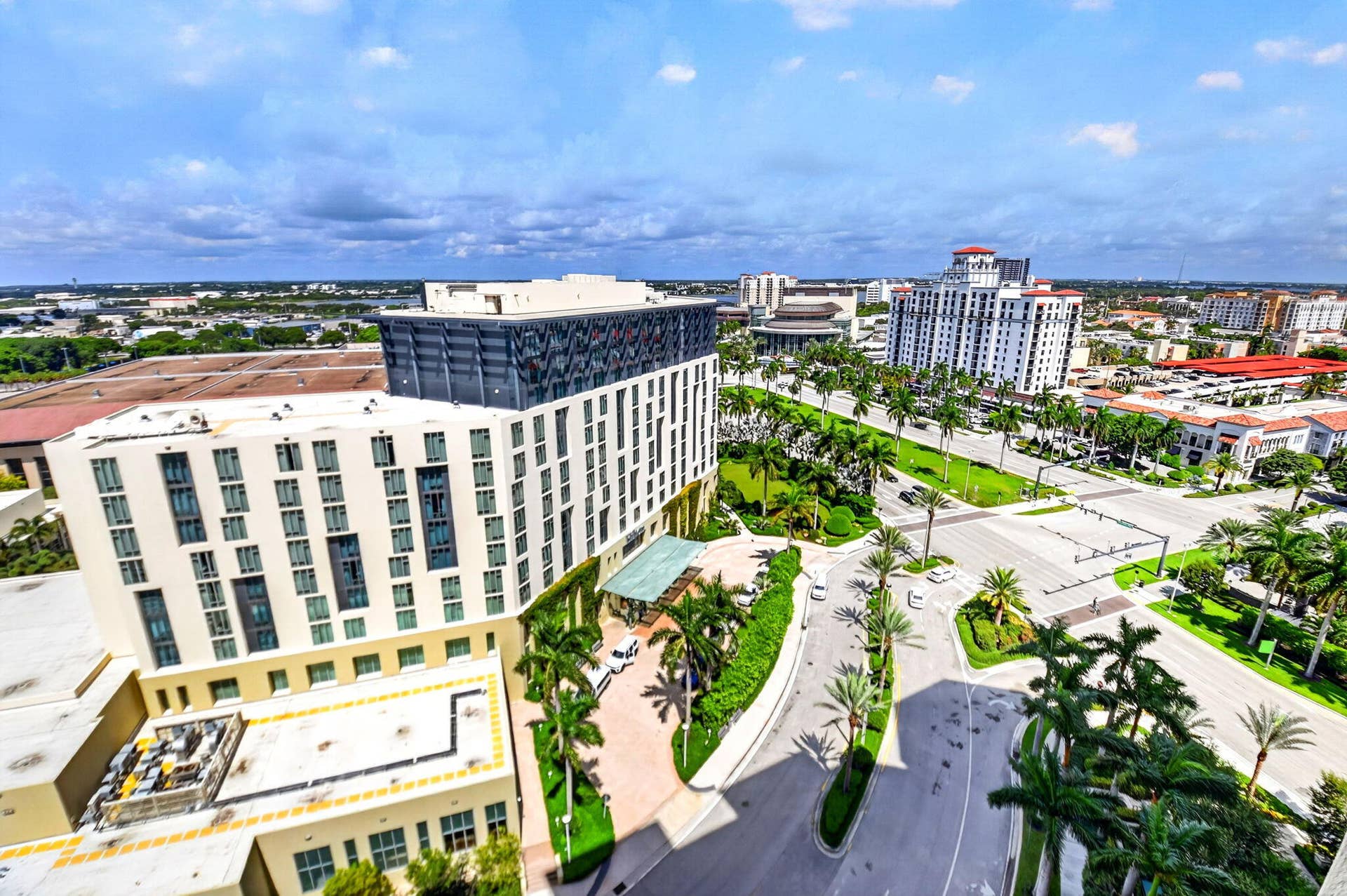550 OKEECHOBEE Boulevard, #1618, West Palm Beach, West Palm Beach, FL 33401 Modern high-rise architecture with a distinctive upper facade, surrounded by structured landscaping, palm trees, and multi-lane roadways
